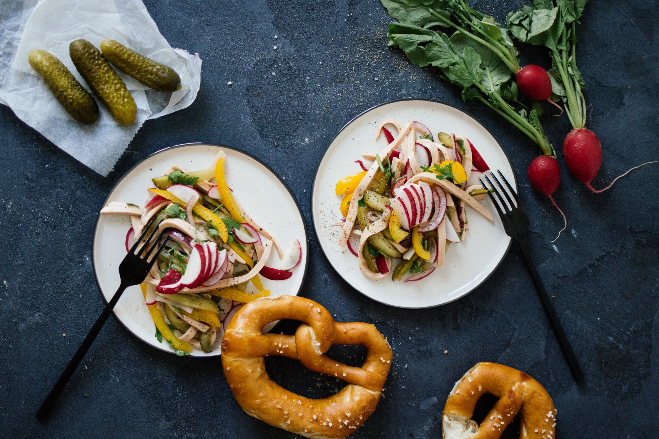 Wurstsalat mit Brezeln auf kleinen Tellern