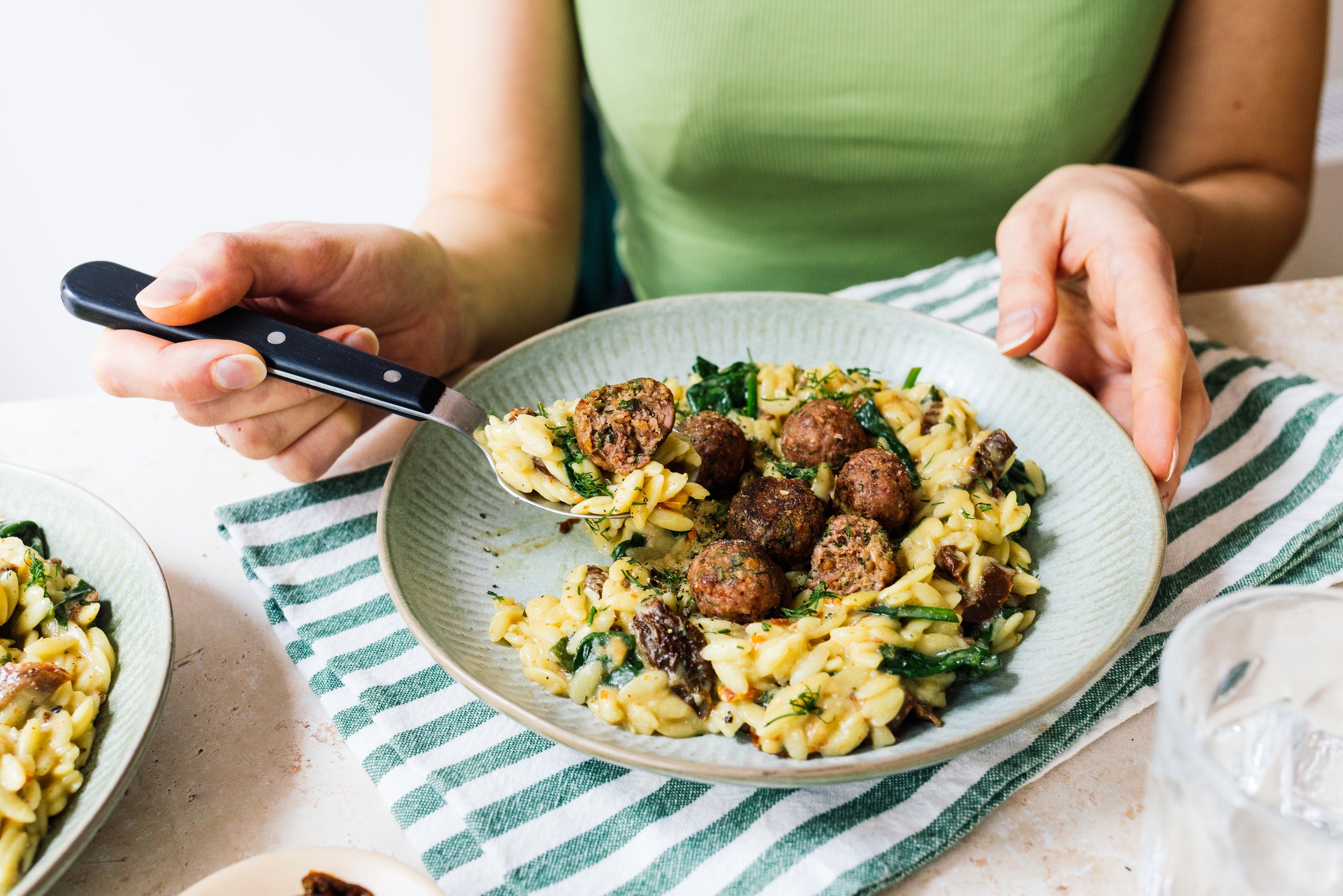 Veganer Orzotto mit Fleischbällchen wird gegessen