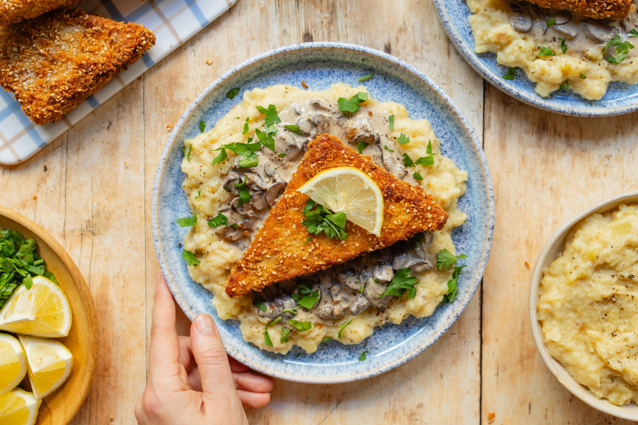 Tempehschnitzel mit Kartoffel-Pastinaken-Püree und Pilzsoße dekoriert auf einem Teller
