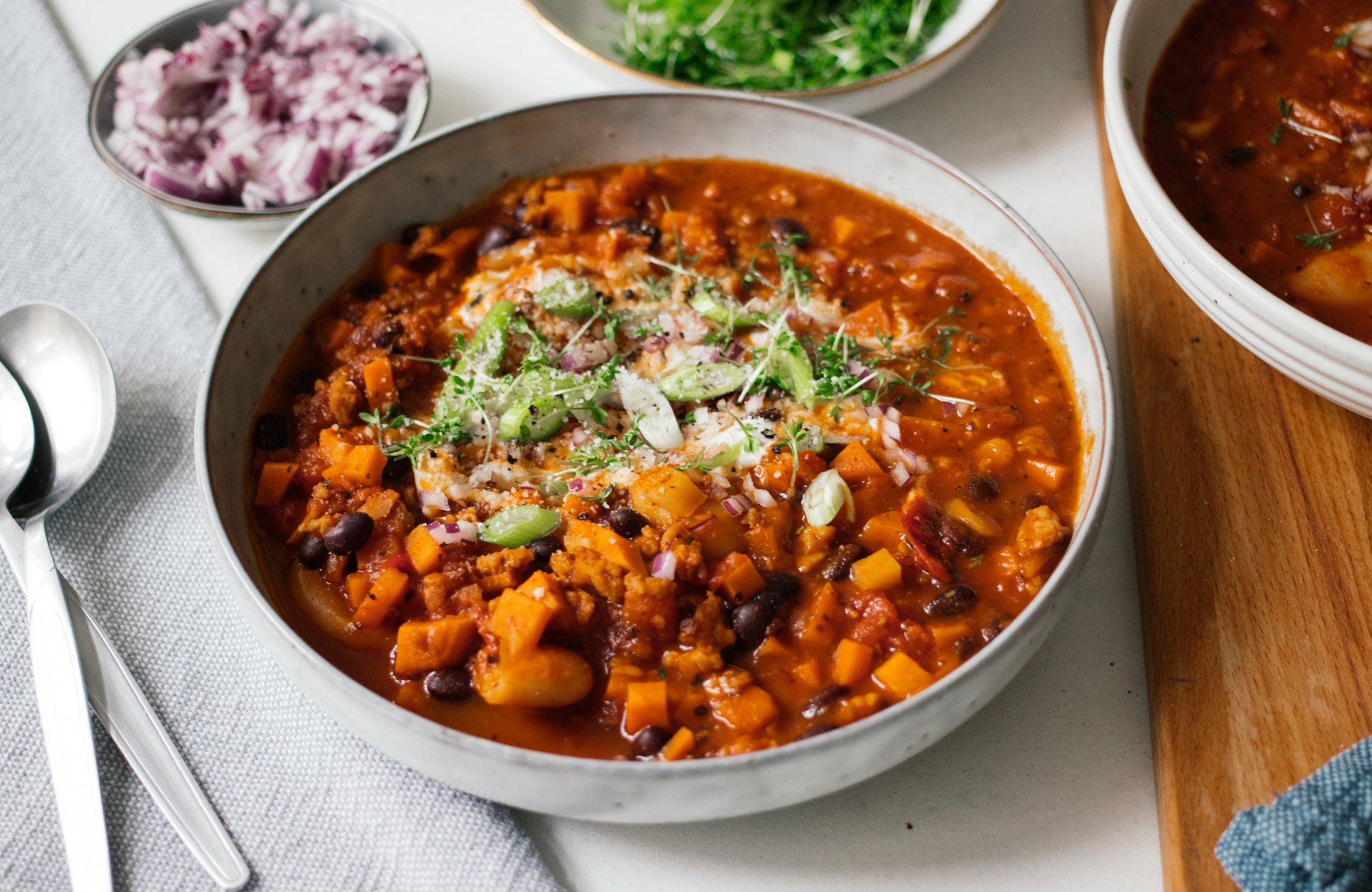 a bowl of vegan chili sin carne served with fresh herbs