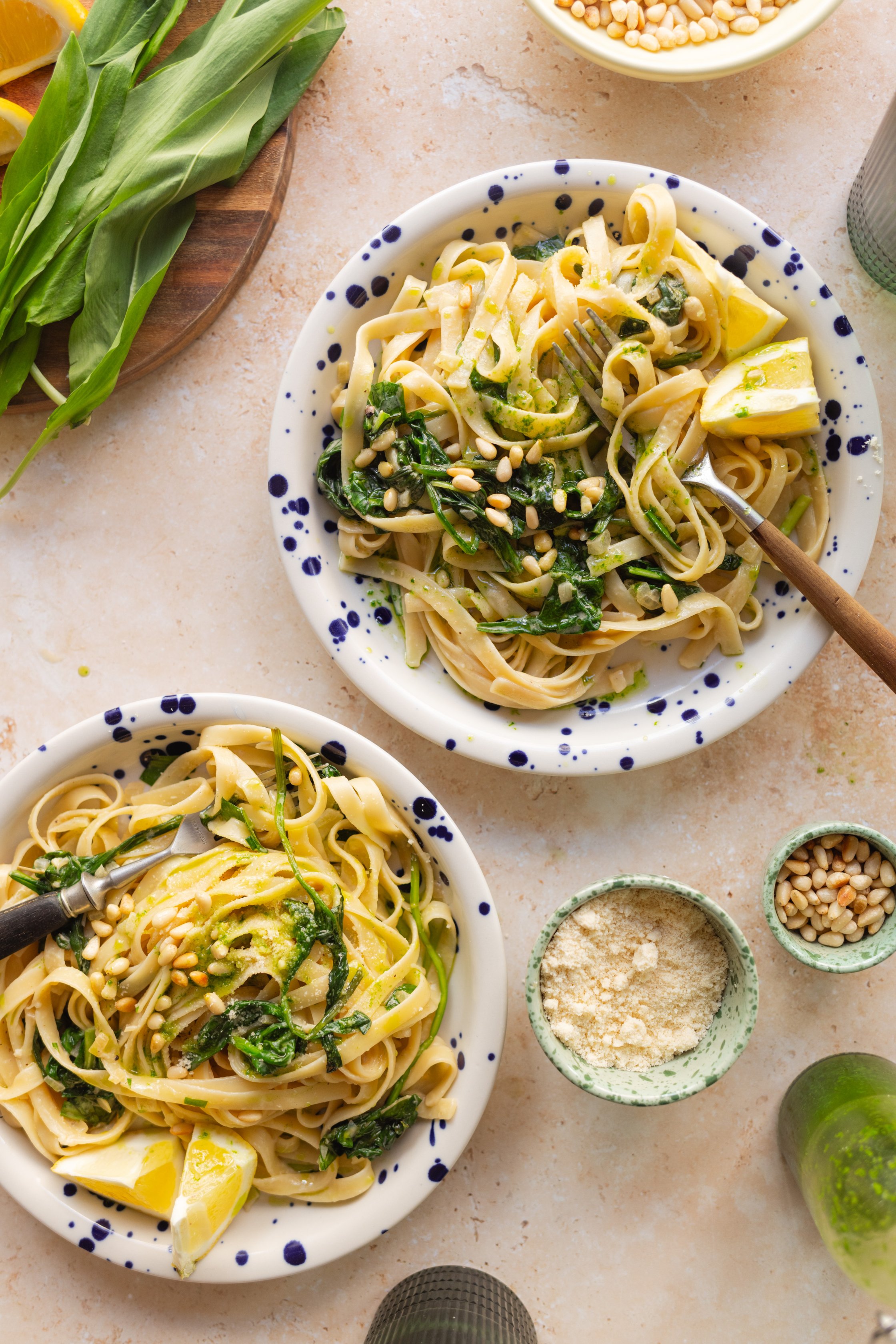 cooked pasta on plates decorated with lemons and pine nuts