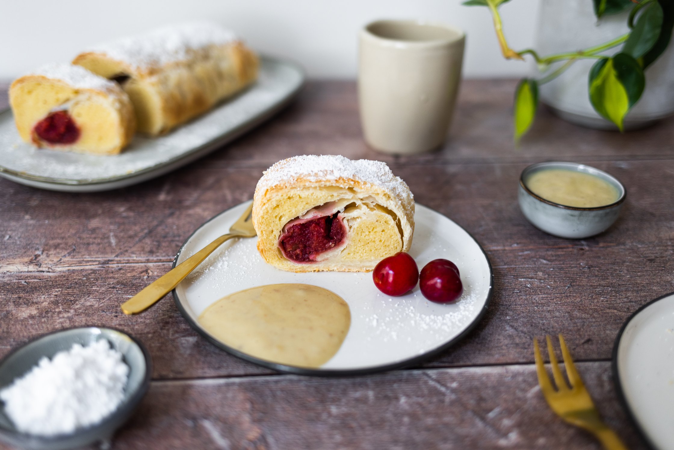 Ein Stück veganer Topfenstrudel auf einem Teller serviert.