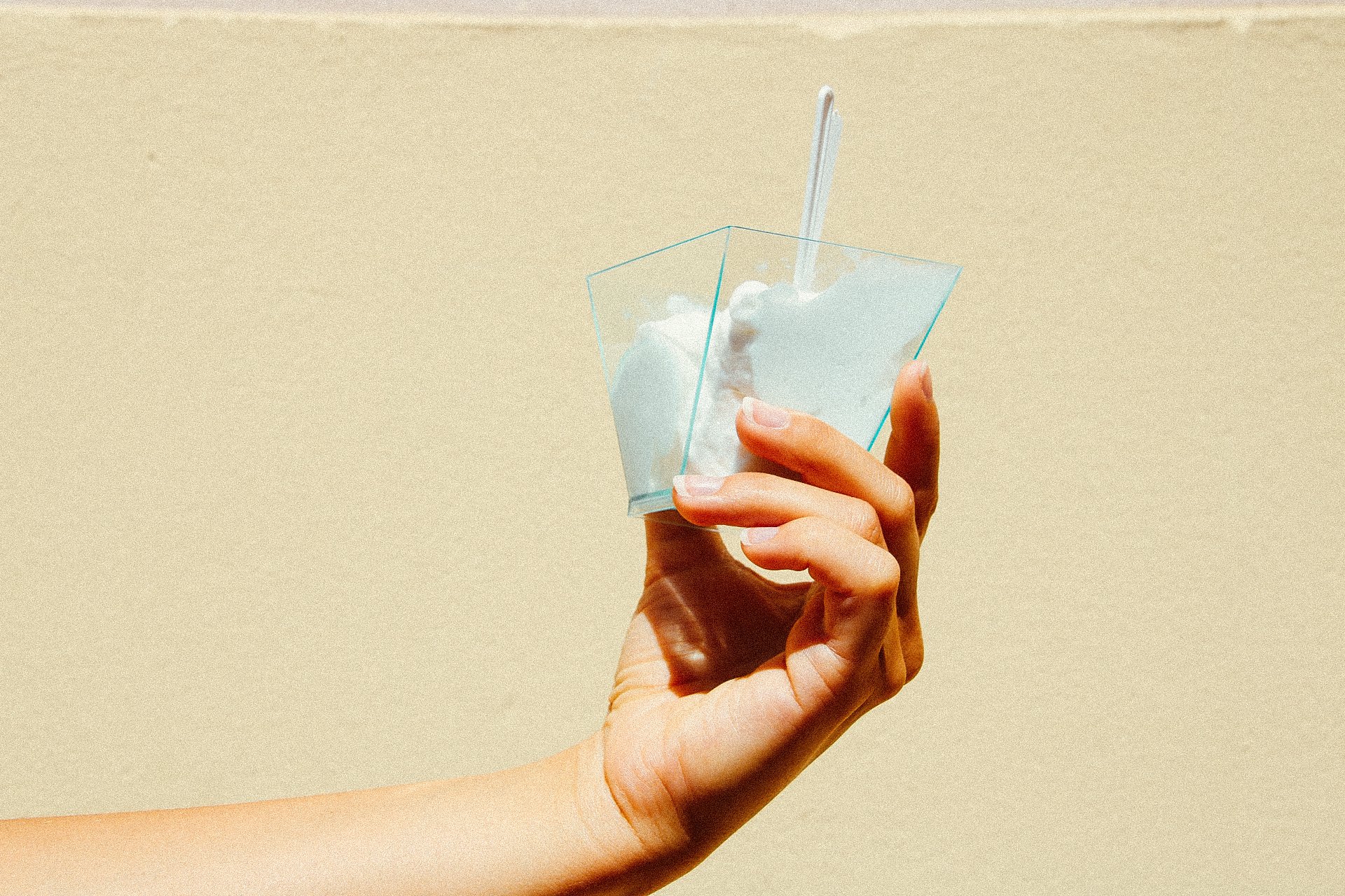 hand holding a cup with coconut ice cream