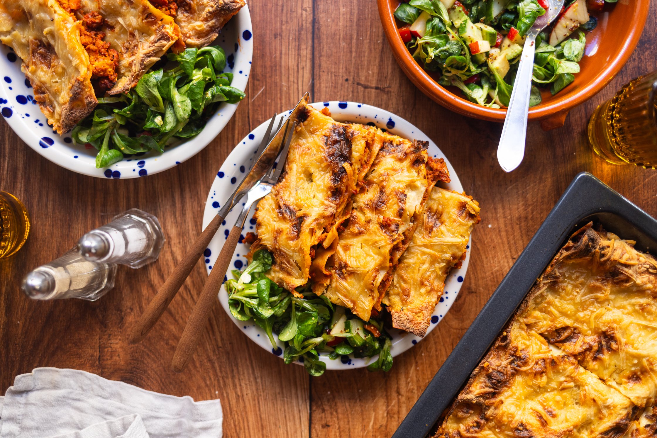 vegane Lasagne vom Blech, auf einem Teller mit Salat angerichtet