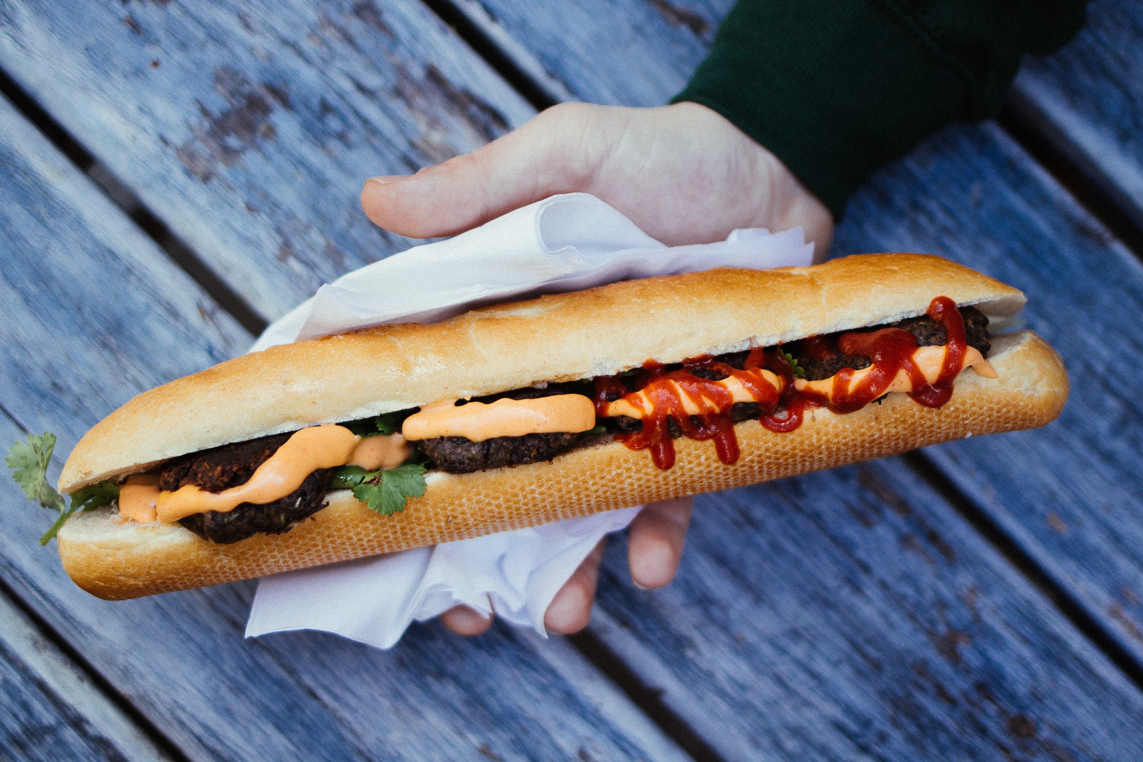 eine Hand hält ein Banh Mi Sandwich