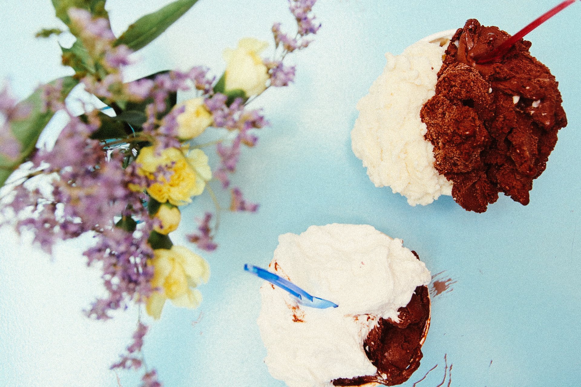 two cups of ice cream on a light blue table
