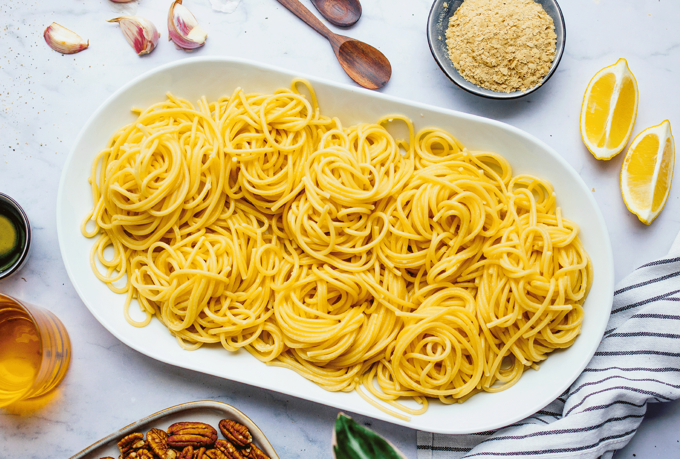 serving pasta, pesto, vegan meatballs, and parsnip on a platter