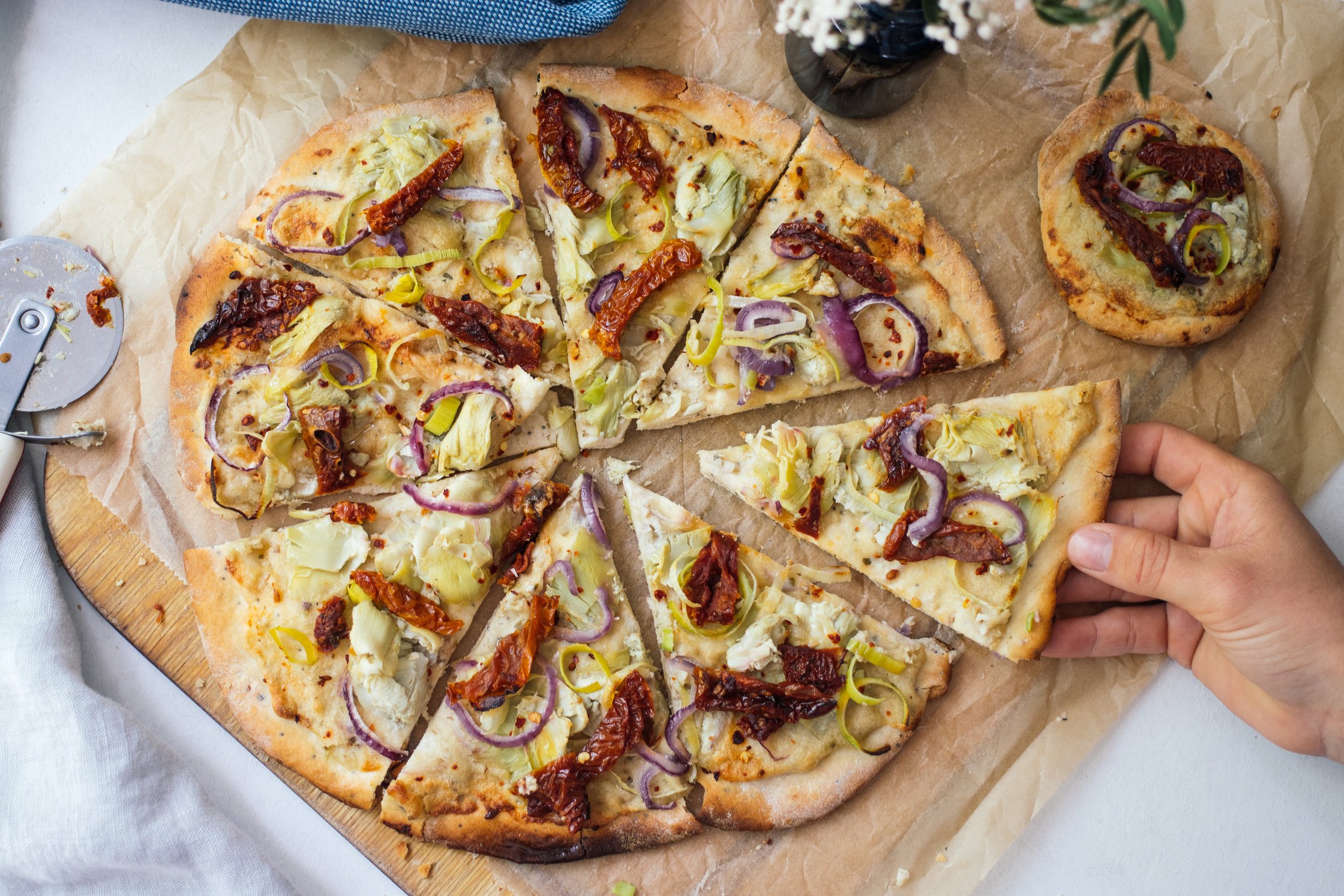 reaching for a slice of vegan pizza