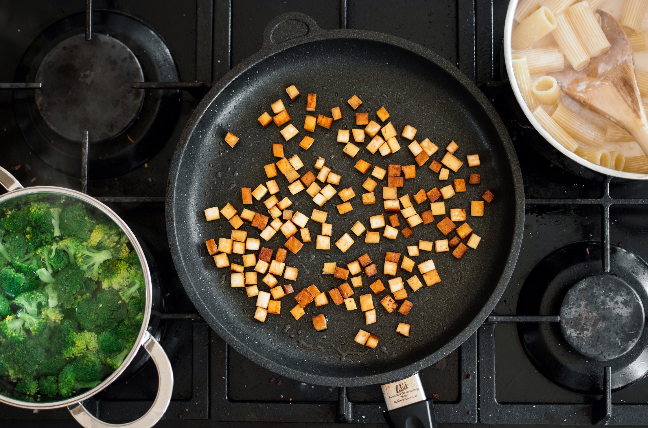 cooking pasta, broccoli, and smoked tofu