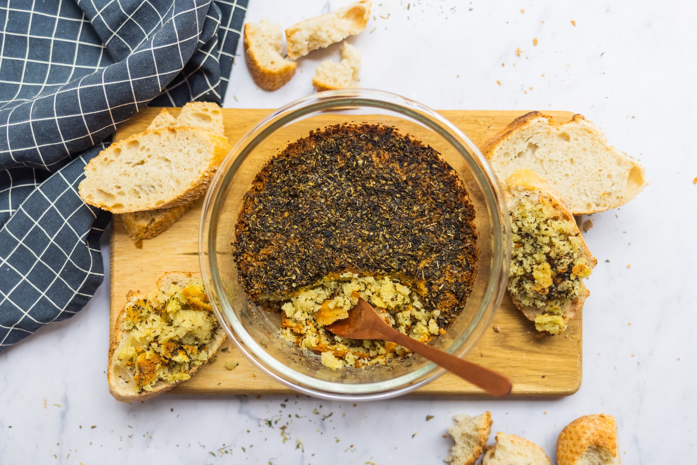 Vegan feta cheese made out of nuts on a board with pieces of baguette