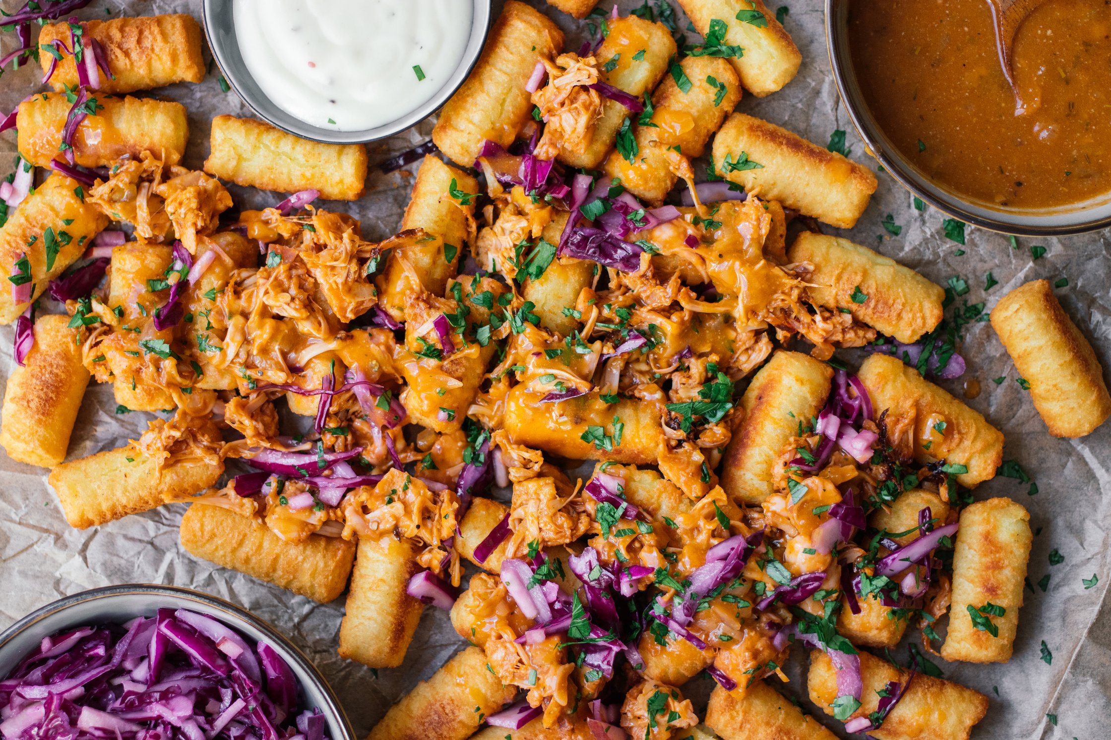 Loaded Tater Tots with Jackfruit, Red Cabbage, And Quick Vegan Gravy on a baking sheet