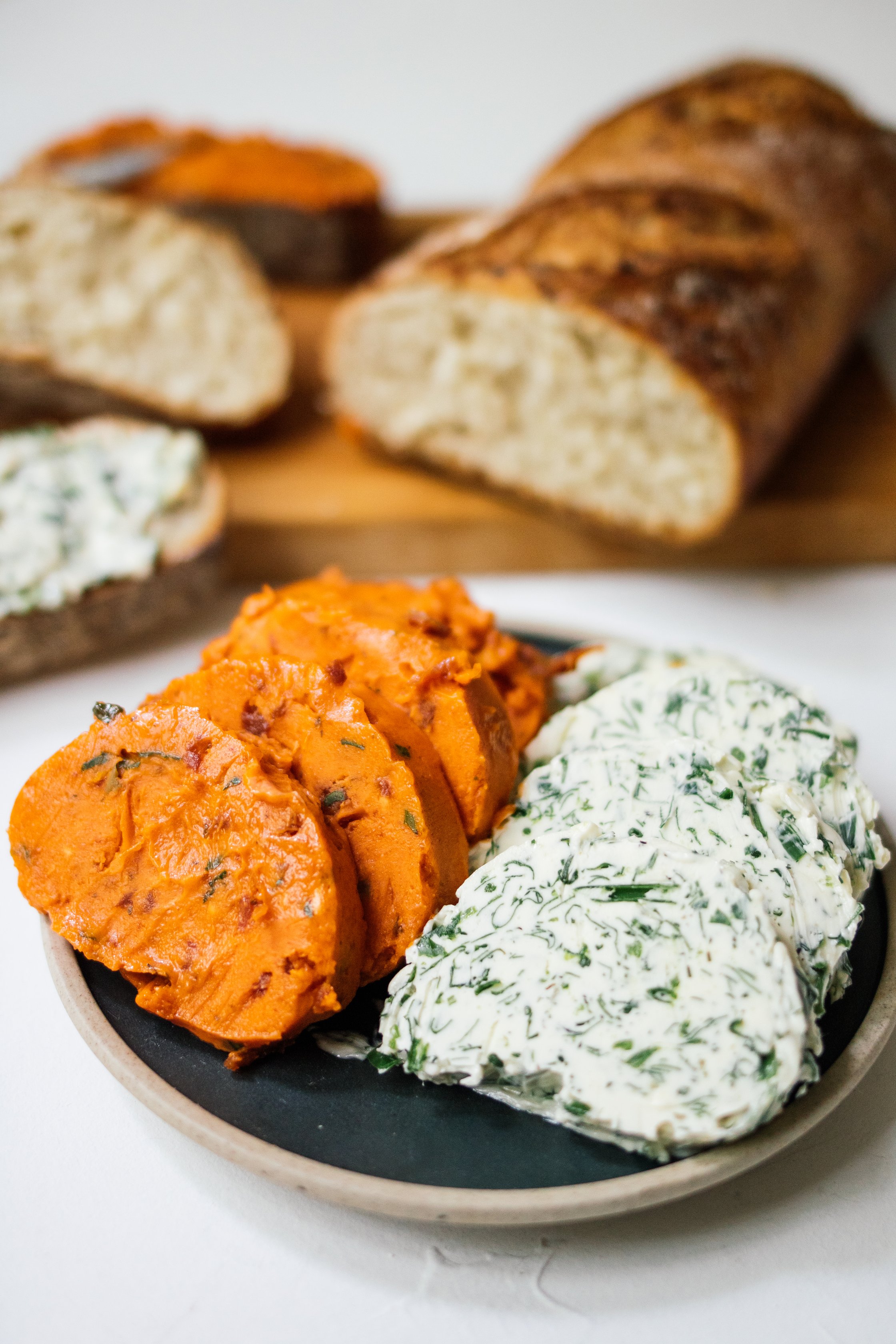 vegane kräuterbutter und brot auf tellern