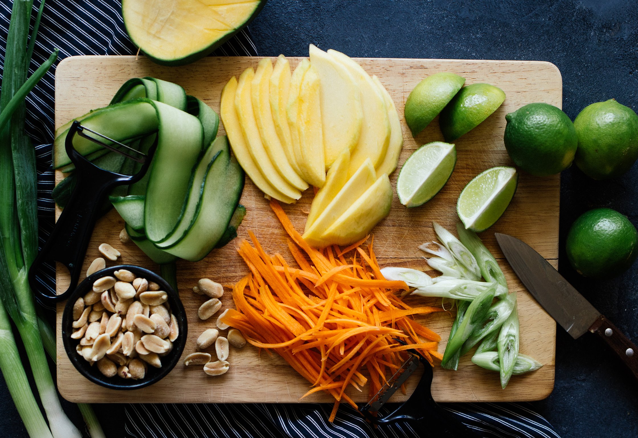 mangi, cucumber and carrots on a wooden board