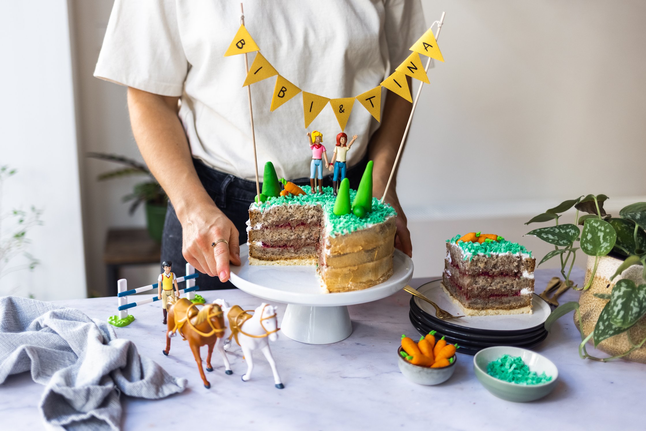 Angeschnittene Bibi und Tina Torte dekoriert mit Bibi und Tina und Bäumen aus Fondant. Die Torte besteht aus einem Biskuitte