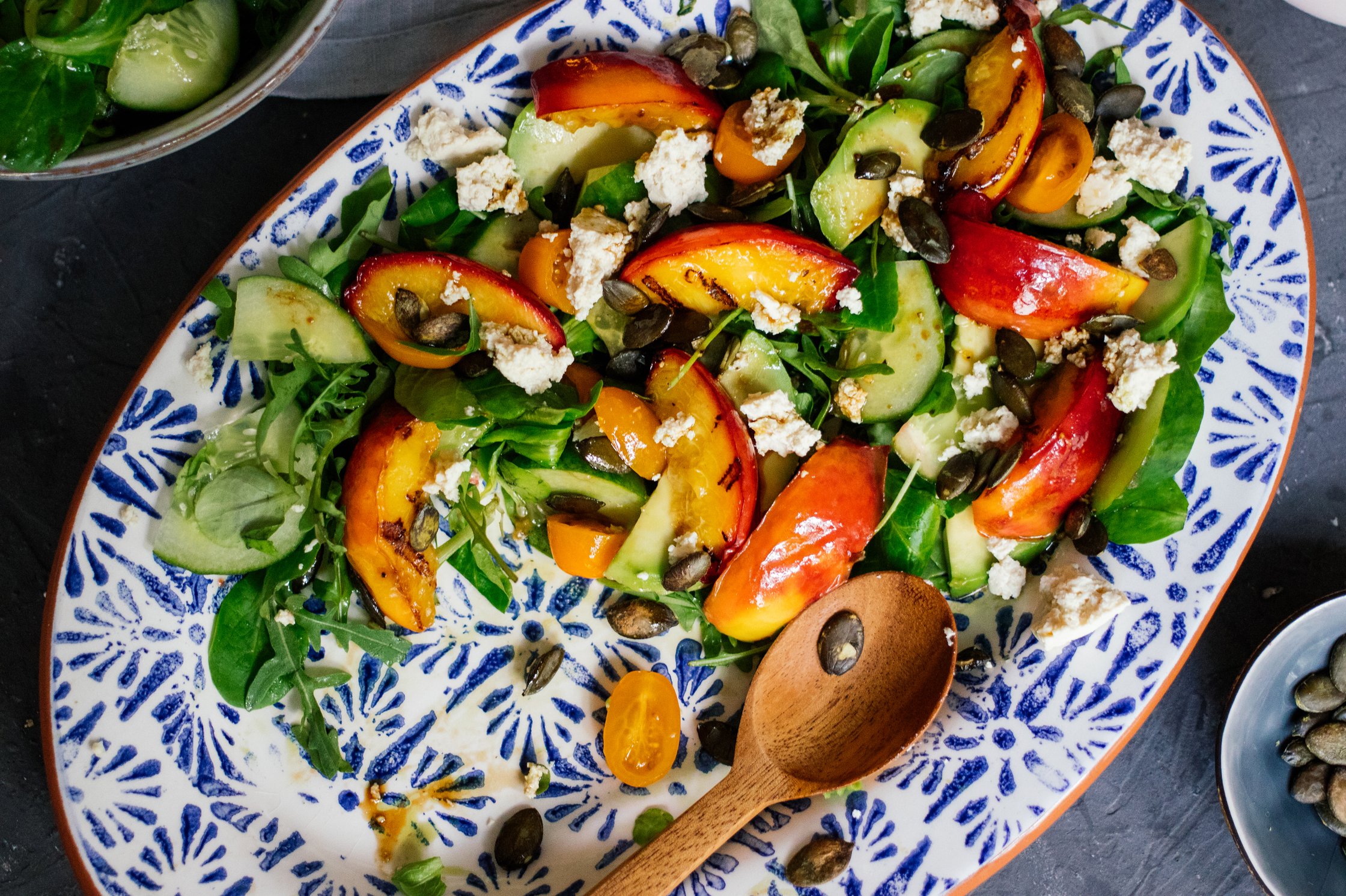 halbvoller teller veganer sommersalat mit gegrilltem pfirsich