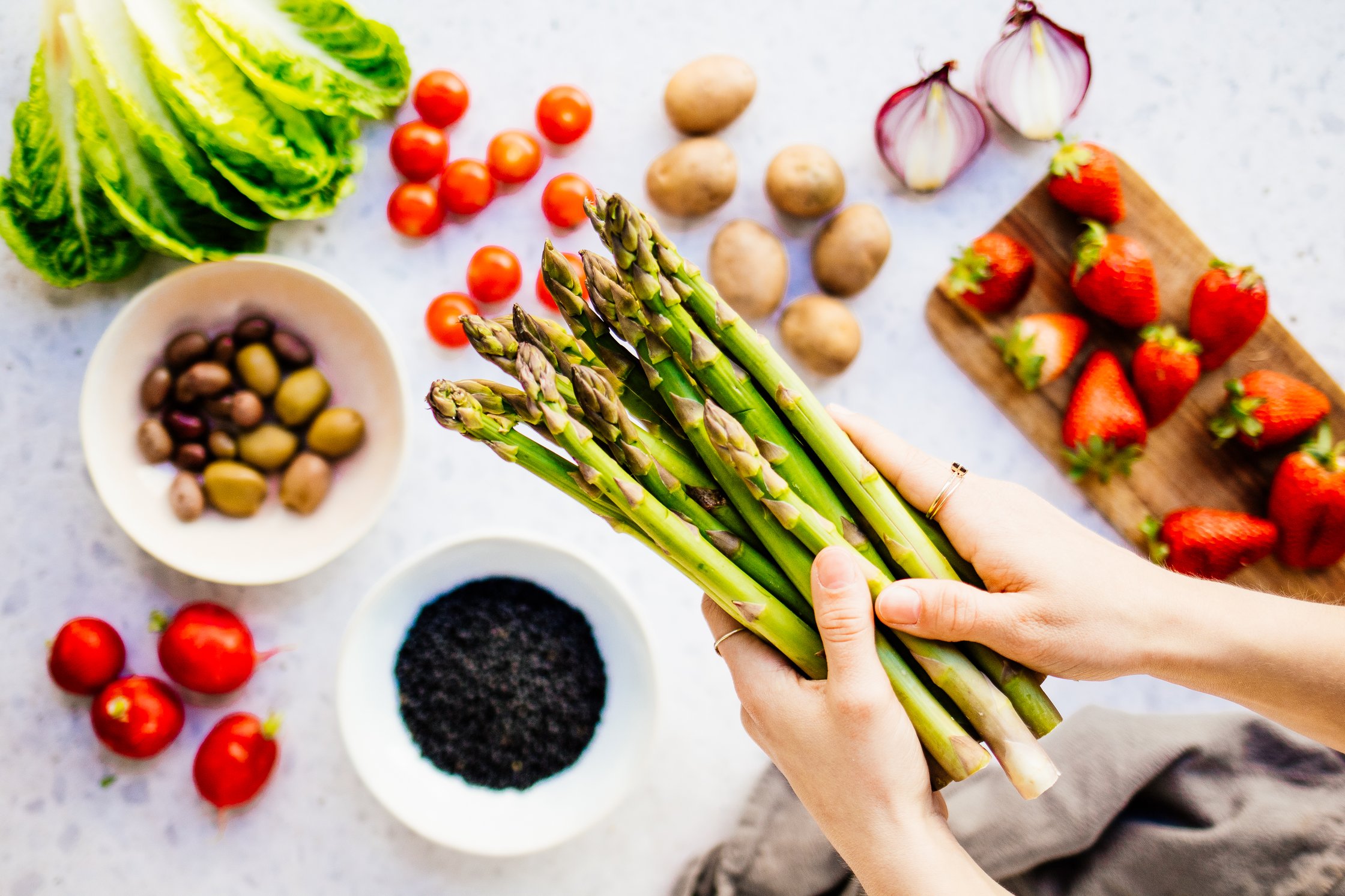 Ingredients for a vegan Asparagus Salad: Tomatos, Onions, Strawberries, Olives, Lentils and Lettuce