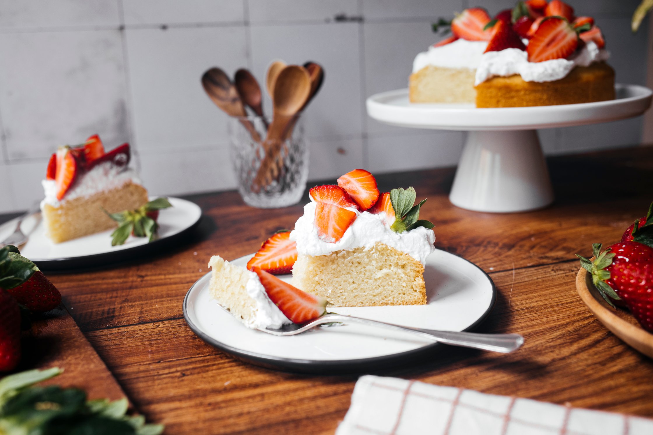 vegan strawberry cake with whipped cream and strawberrys on a small plate
