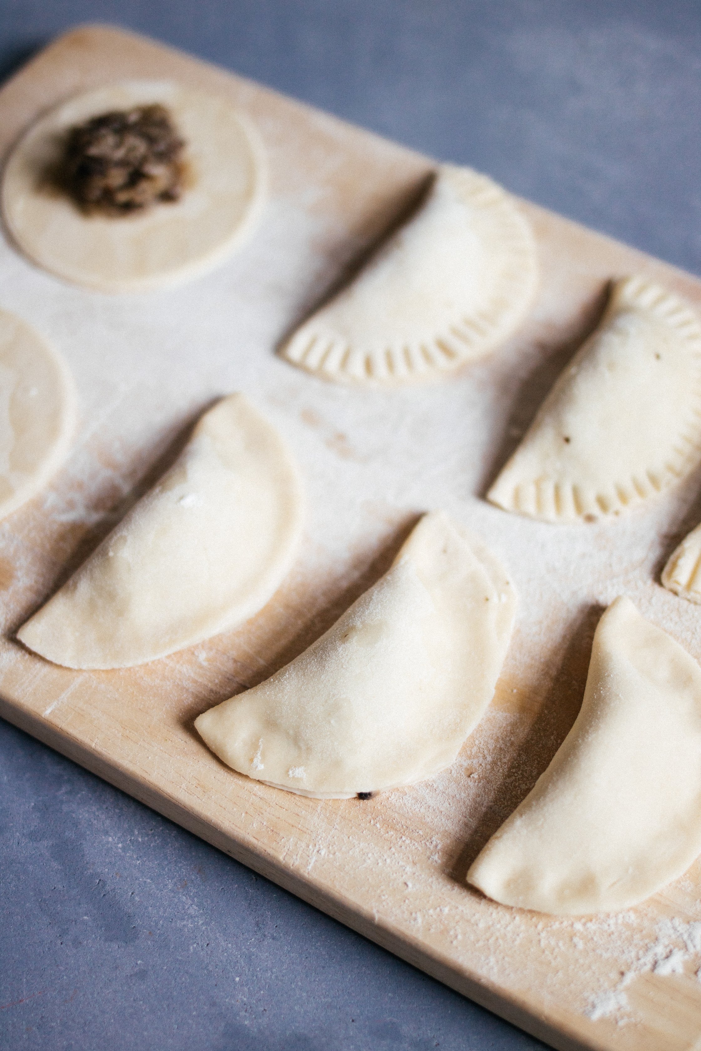 folded pierogis on a wooden board