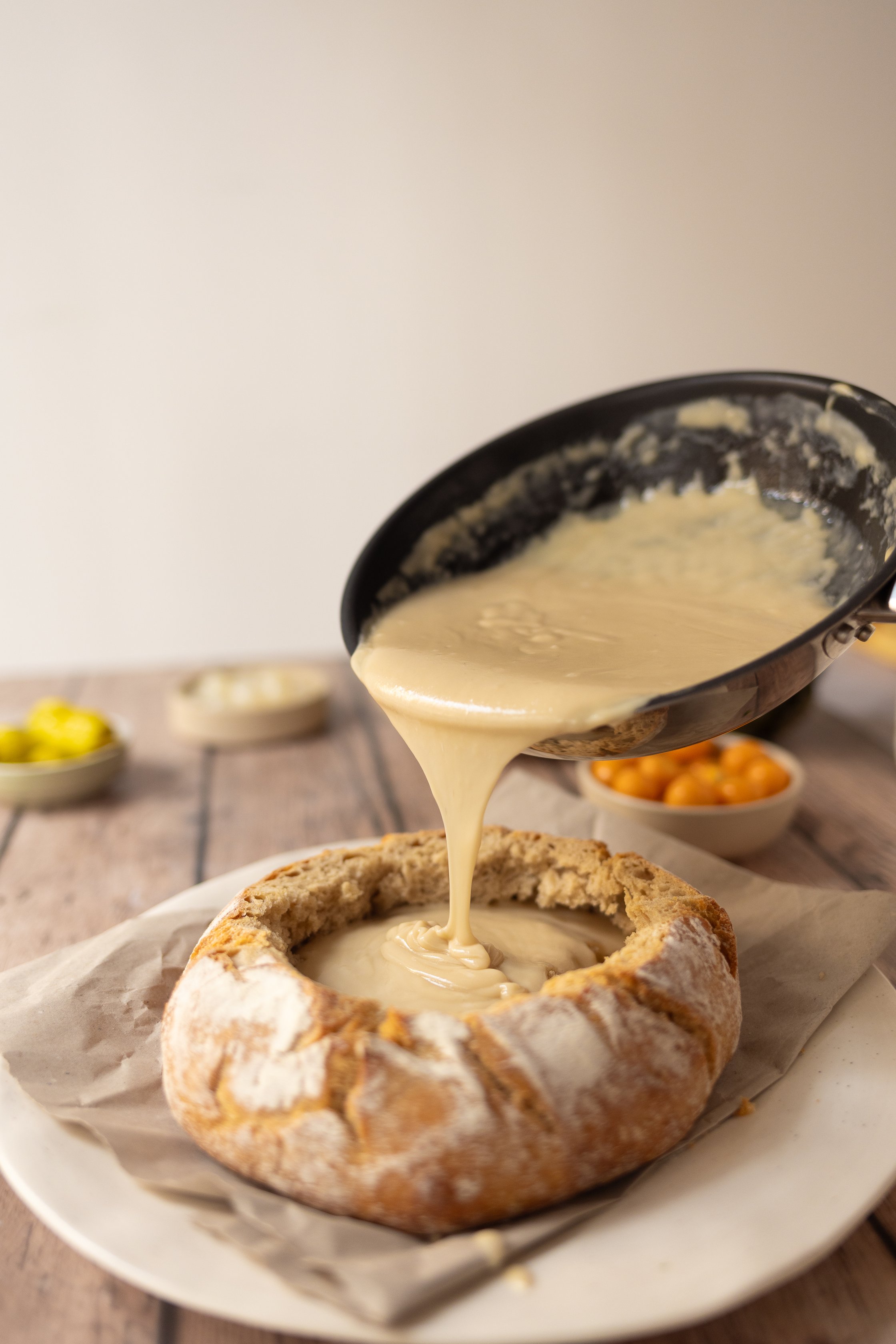 Fondue wird in das Brot gefüllt.