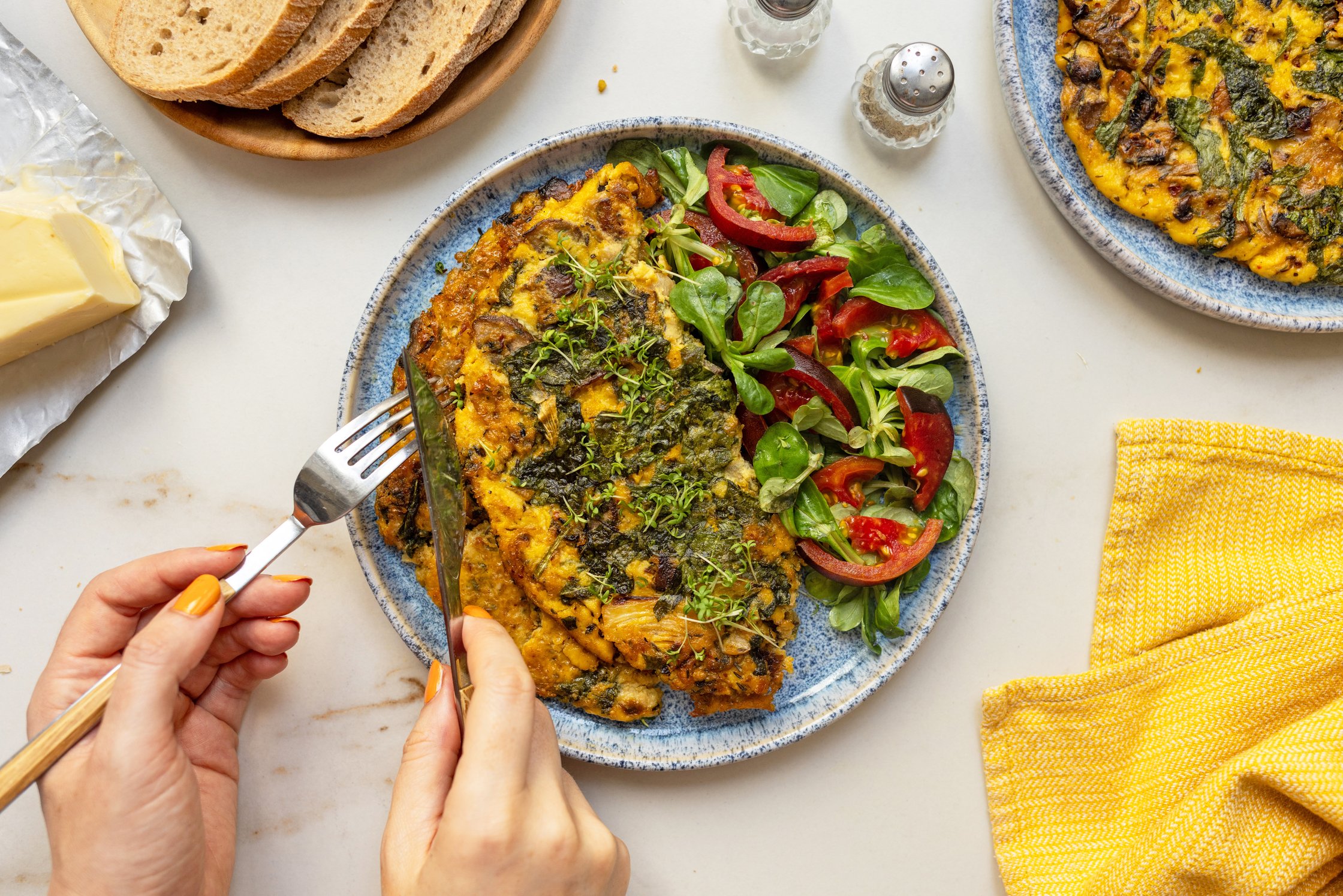 Ein Top-Shot von einem geüllten Teller mit veganem Omelette und frischem Salat.