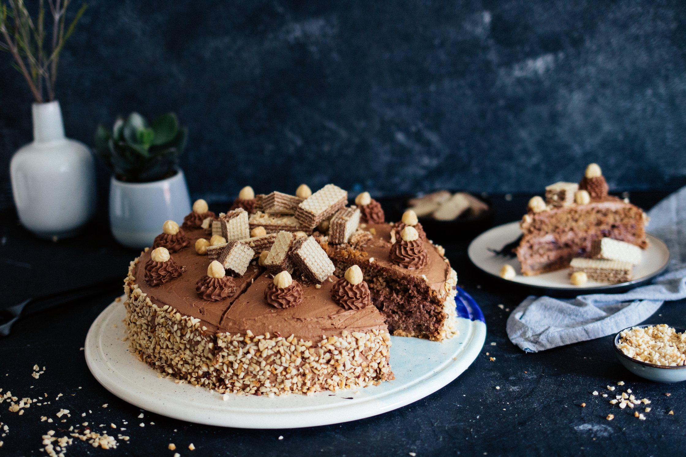 vegane Haselnusstorte mit Nougatcreme auf einer Kuchenplatte