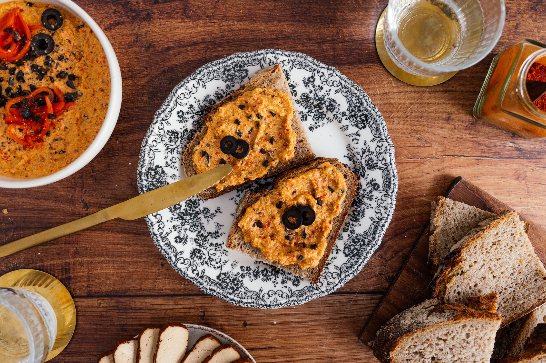 gedeckter Tisch mit Brot und veganem Paprika-Aufstrich