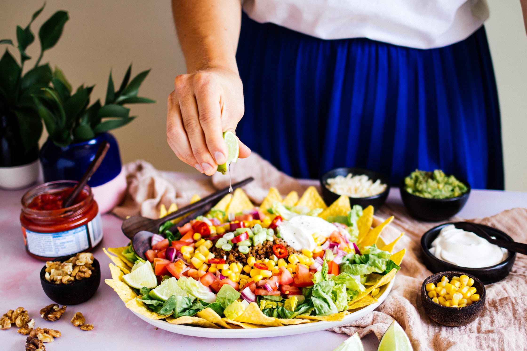 frischer Limettensaft wird auf veganen Taco Salat geträufelt