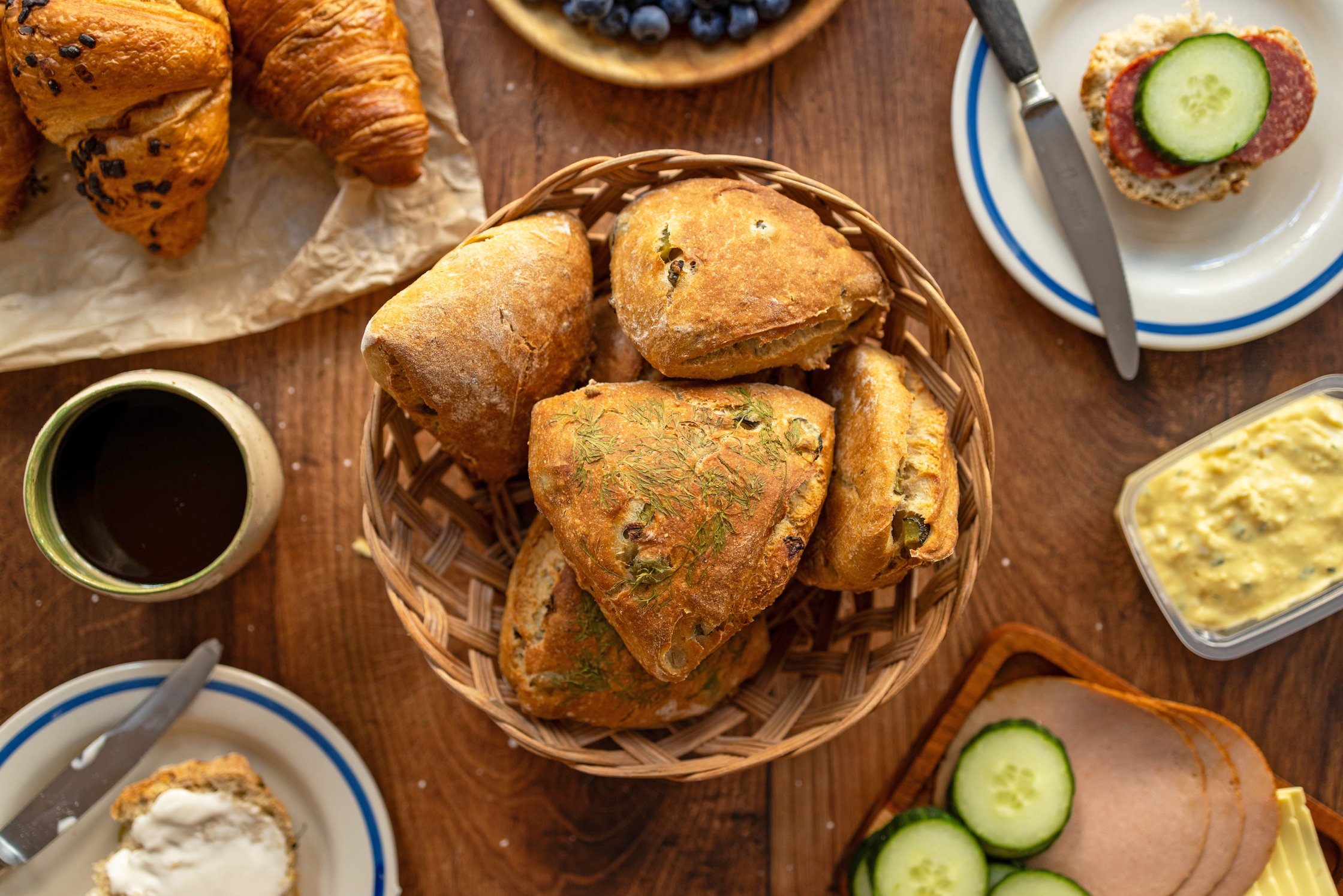 Selbstgebackene Sonntagsbrötchen mit Gewürzgurken und Dill in einem brotkorb