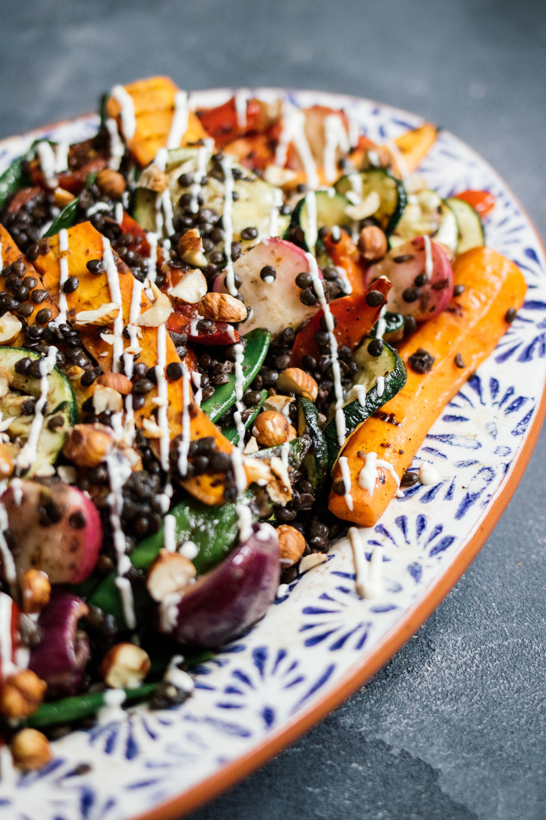Grillgemüsesalat mit Belugalinsen und Sesamdressing auf einem teller