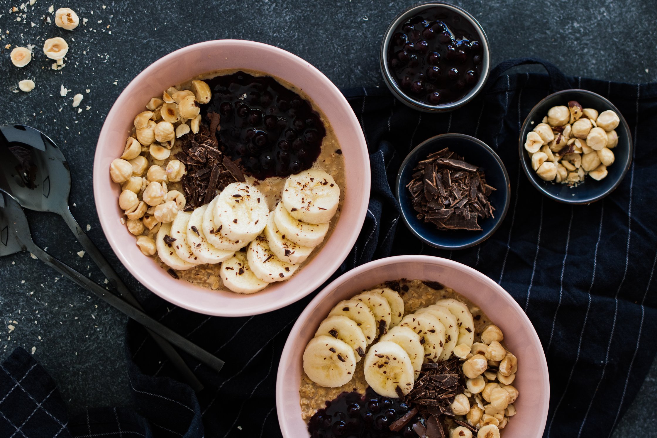 veganes Chai-Porridge neben Heidelbeeren, Schokolade und Haselnüssen