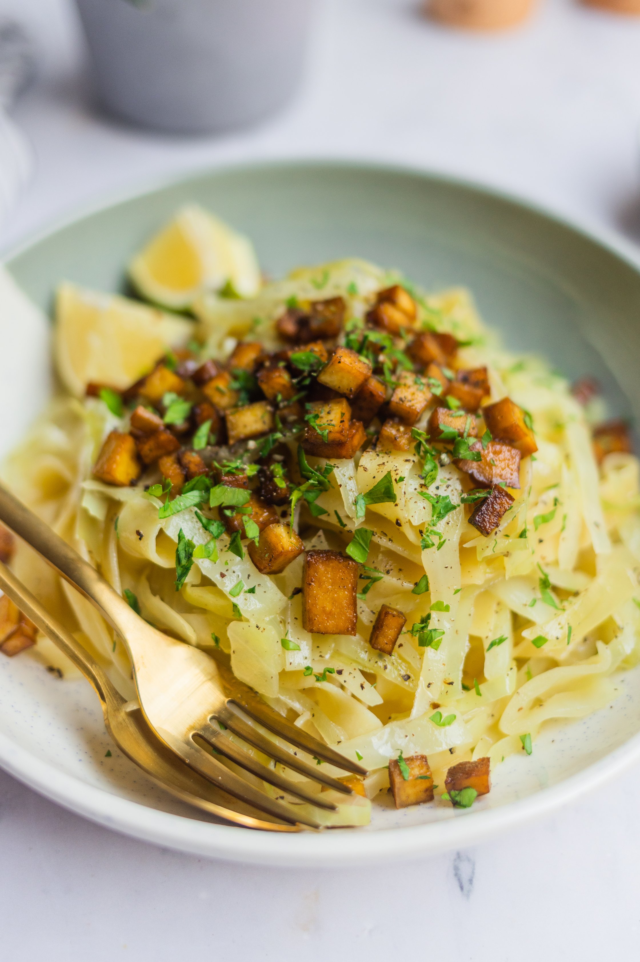 Nahaufnahme von veganen Kraut-Zwiebel-Nudeln auf einem Teller.