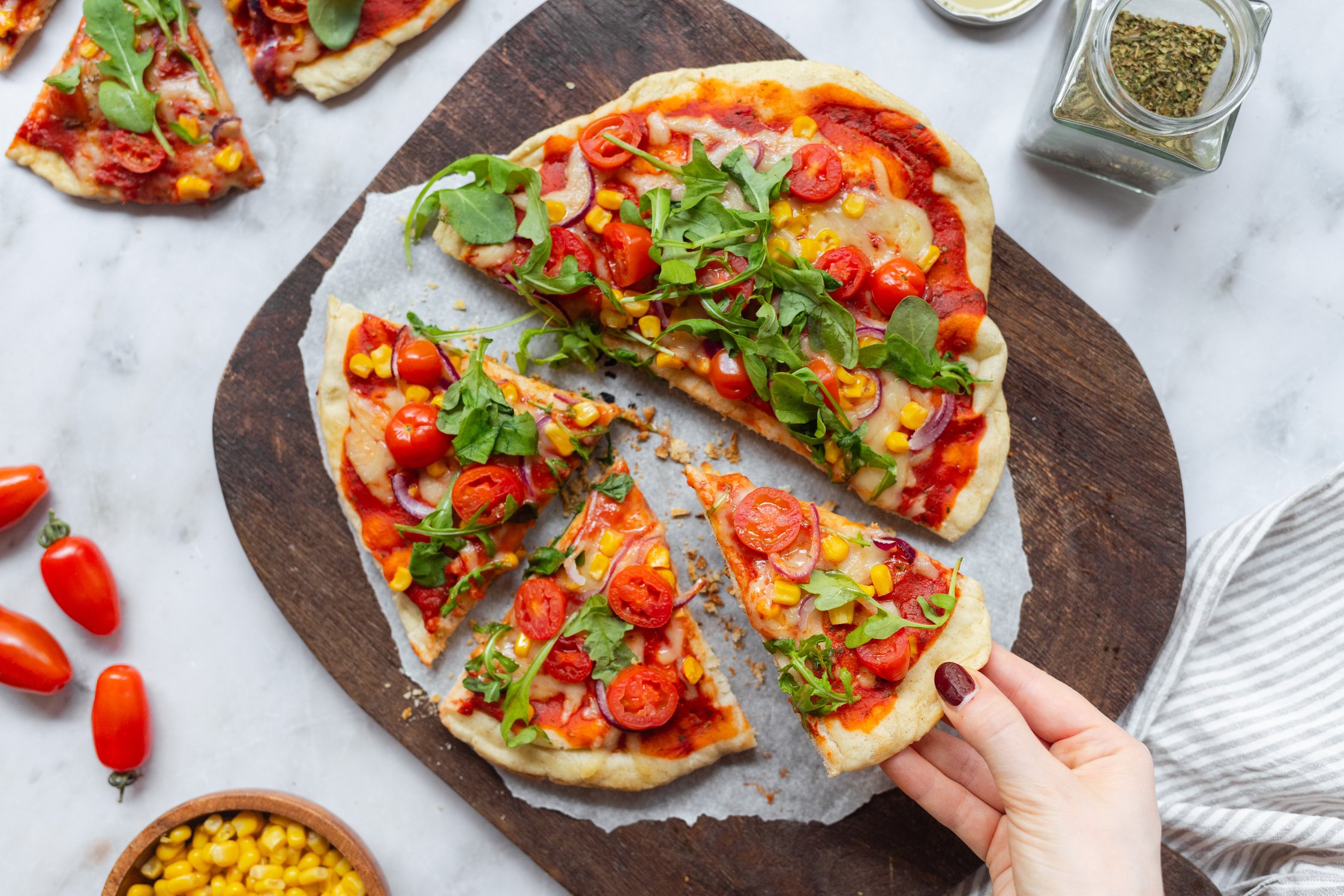 pizza cut into pieces on a wooden board