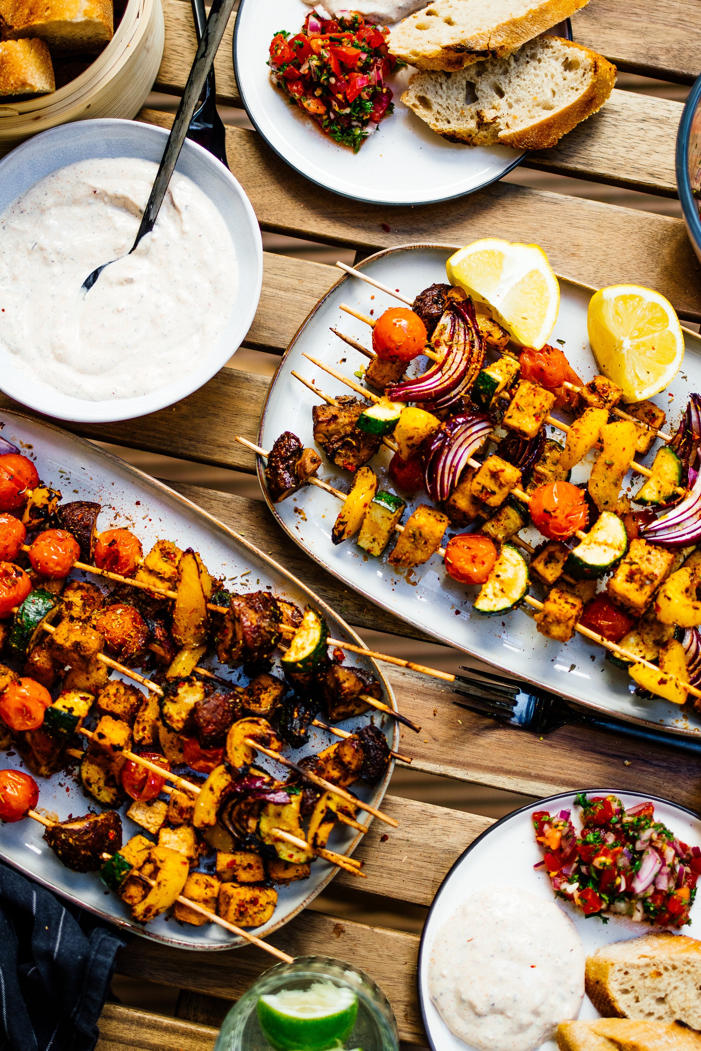 Gedeckter Tisch mit Tofu-Spießen, Baguette, Zitrone, veganem Quark