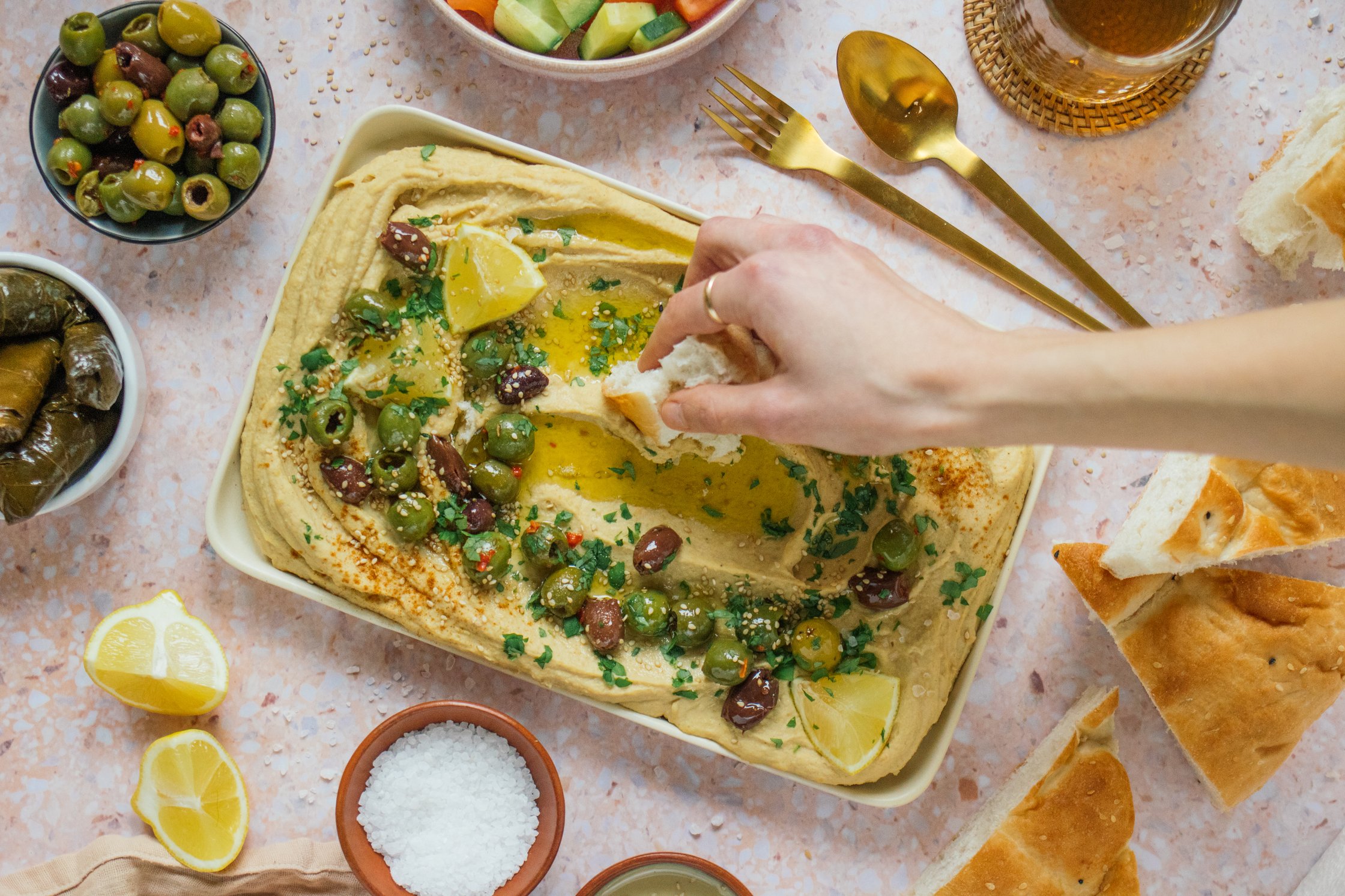 hand dipping flatbread into hummus