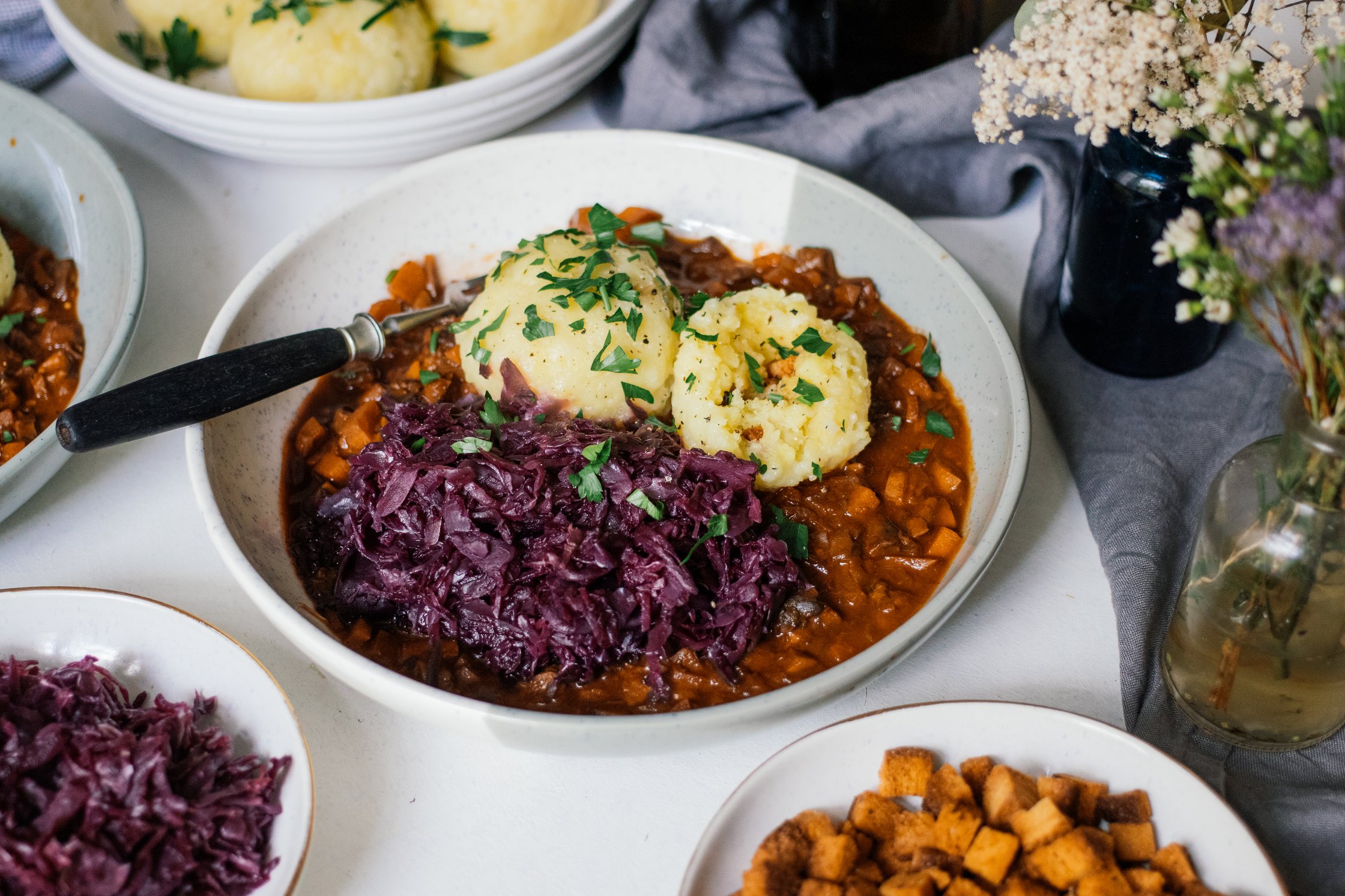 Vegan Potato Dumplings with Mushroom Ragout and Red Cabbage served on the table