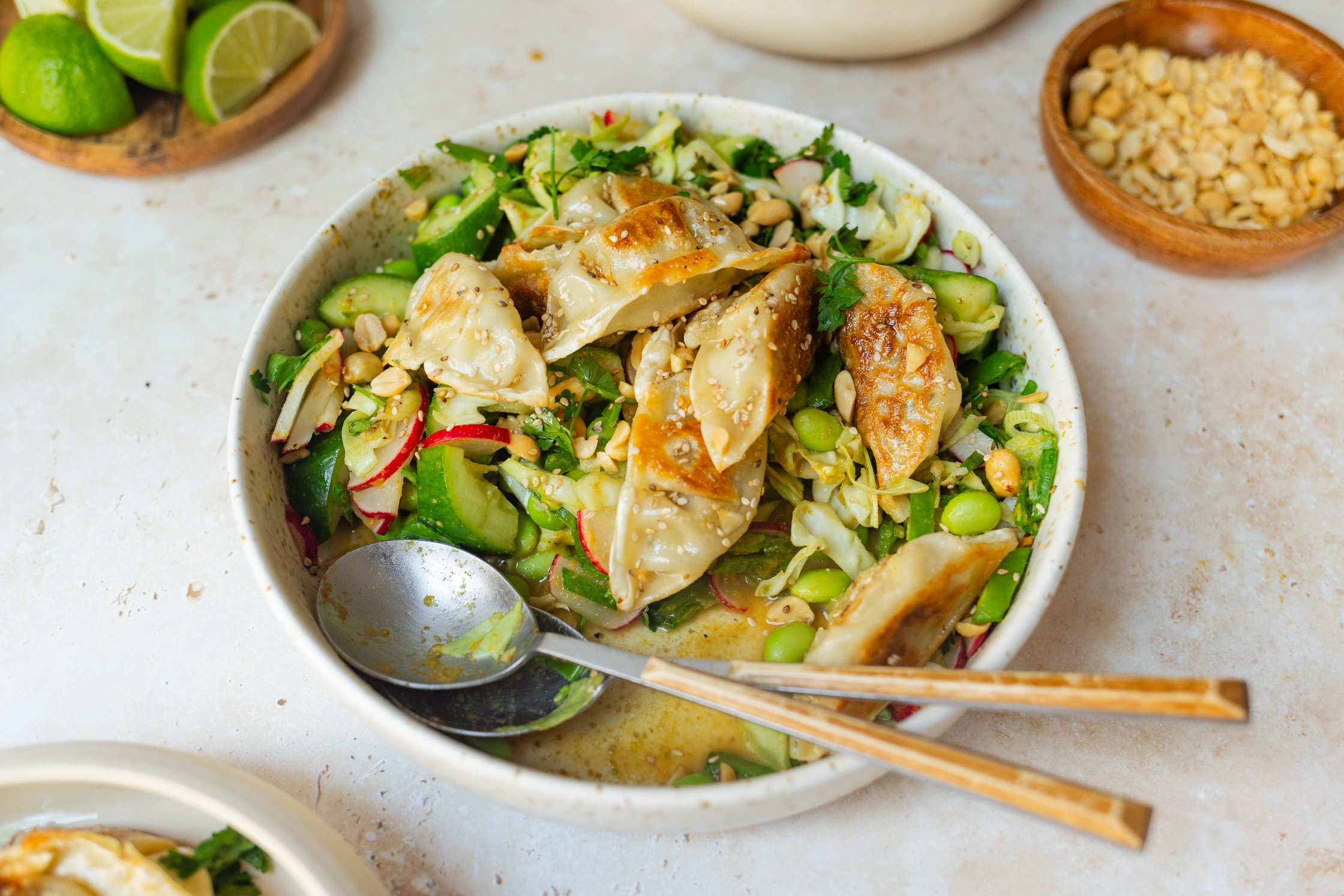 knuspriger Dumpling Salat mit Currydressing auf einem Teller mit Besteck