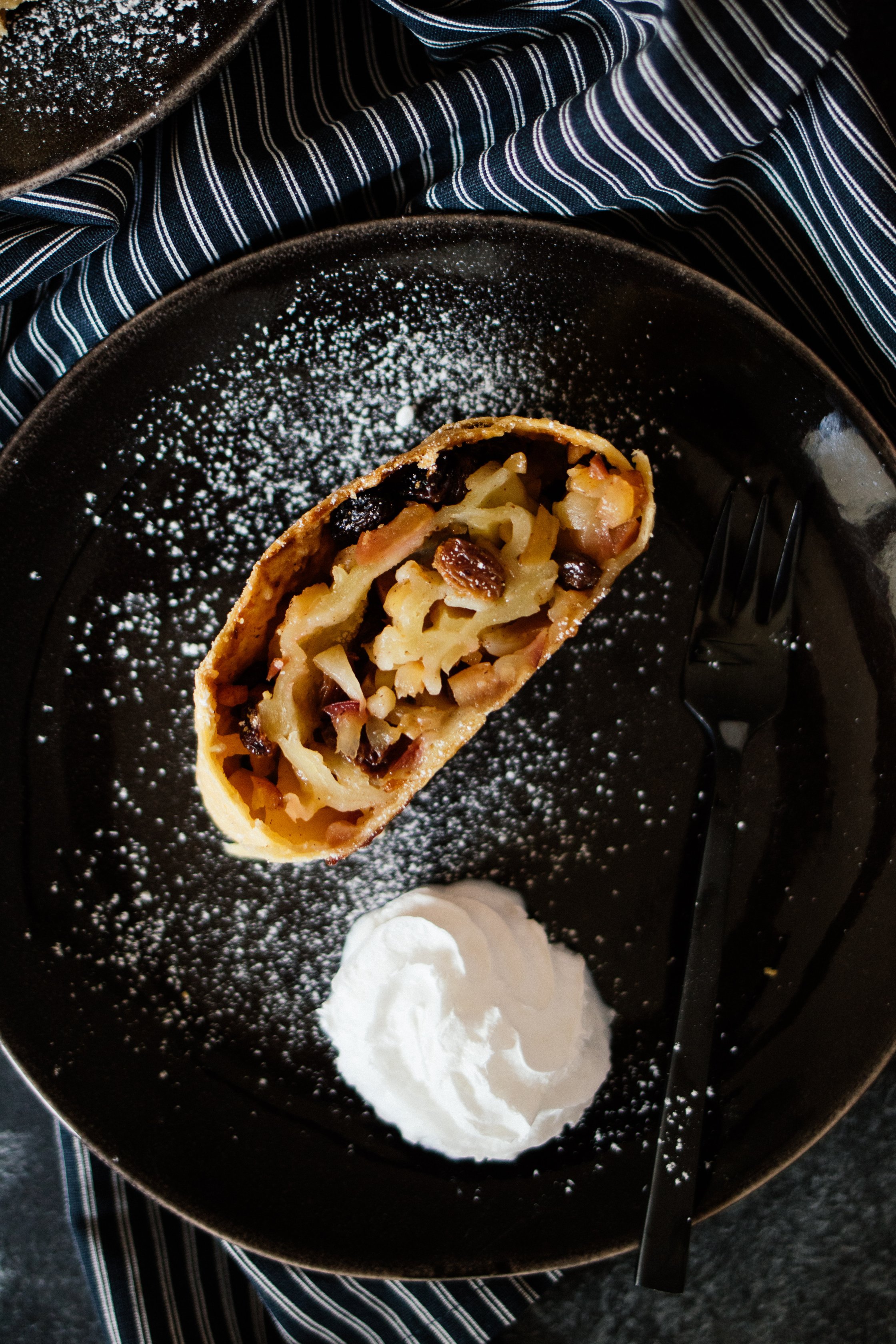 a piece vegan apple strudel on a black plate
