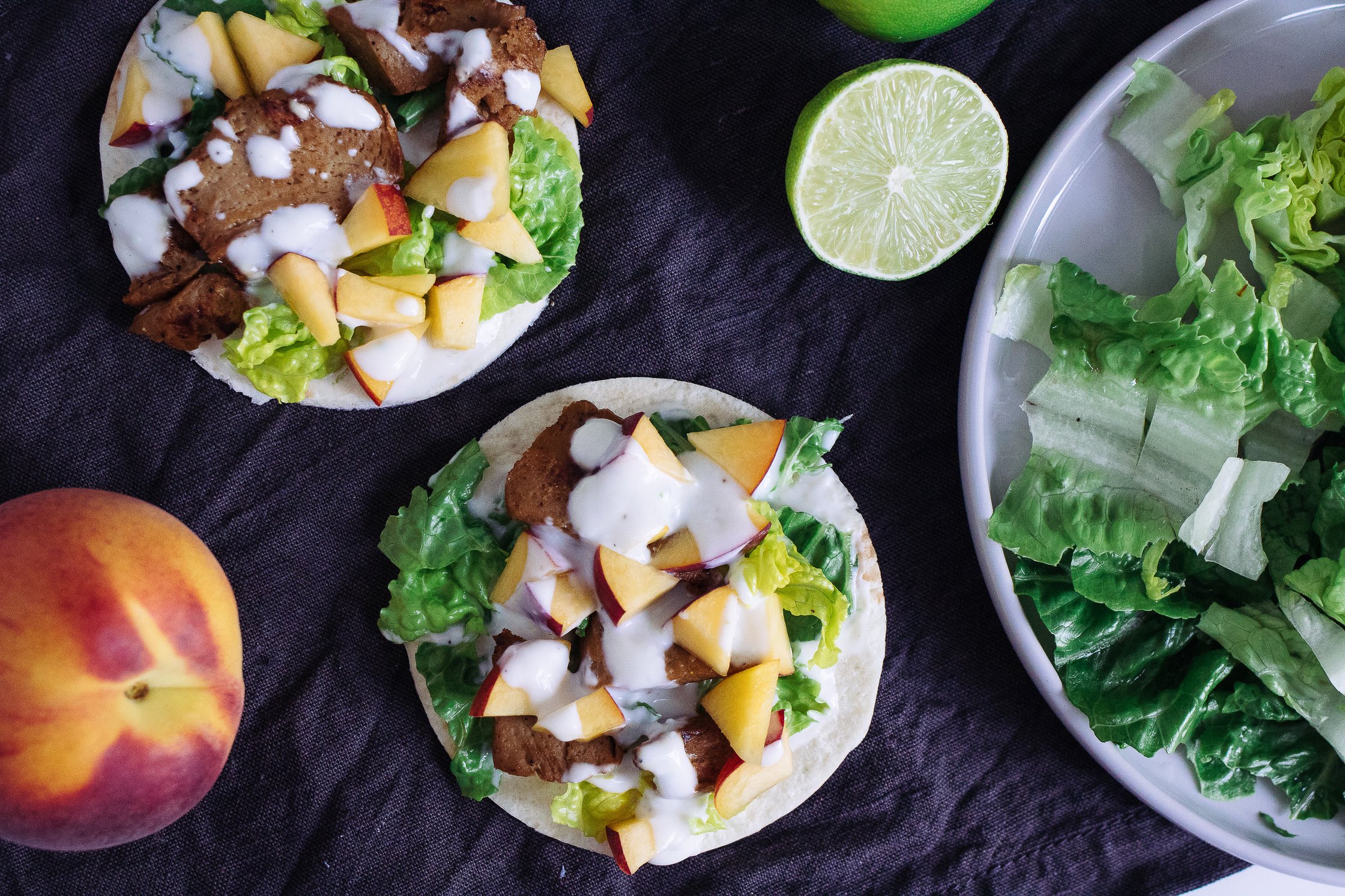 zwei Tacos liegen auf dunklem Untergrund und sind fertig