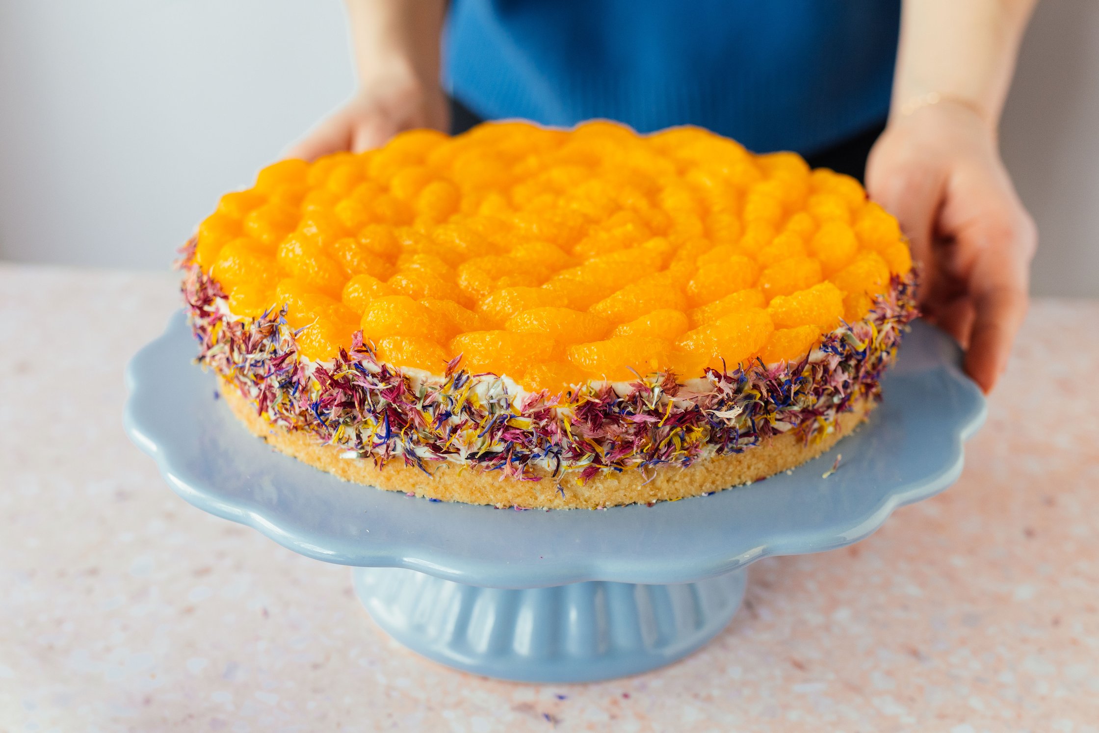 vegan cream and mandarin cake with flower coating on a cake platter