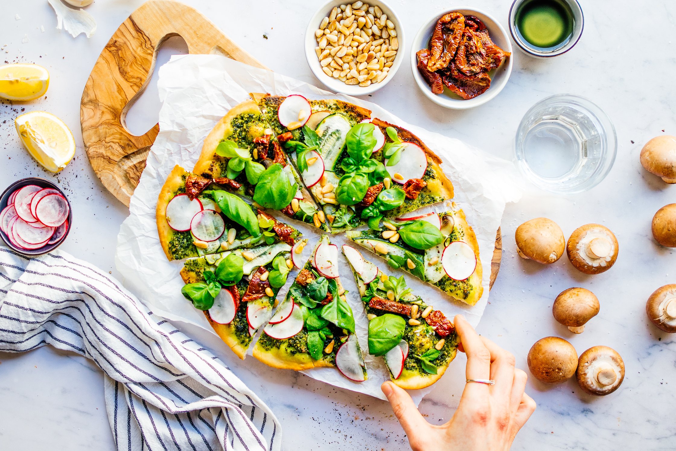 frische Kräuter auf veganer Pesto Pizza