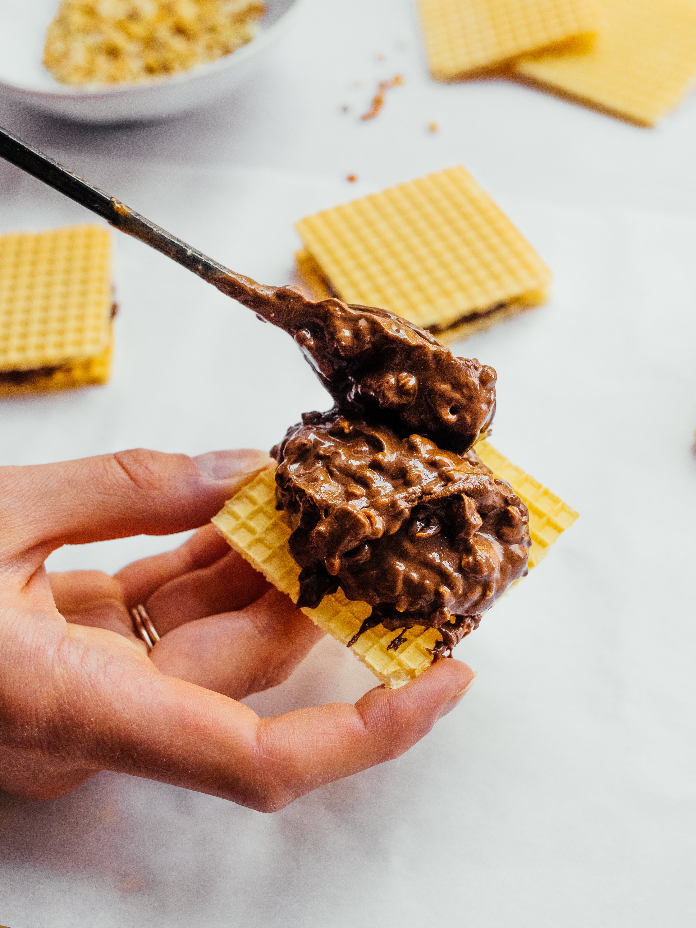 spoon spreading filling for vegan hanuta on waffle