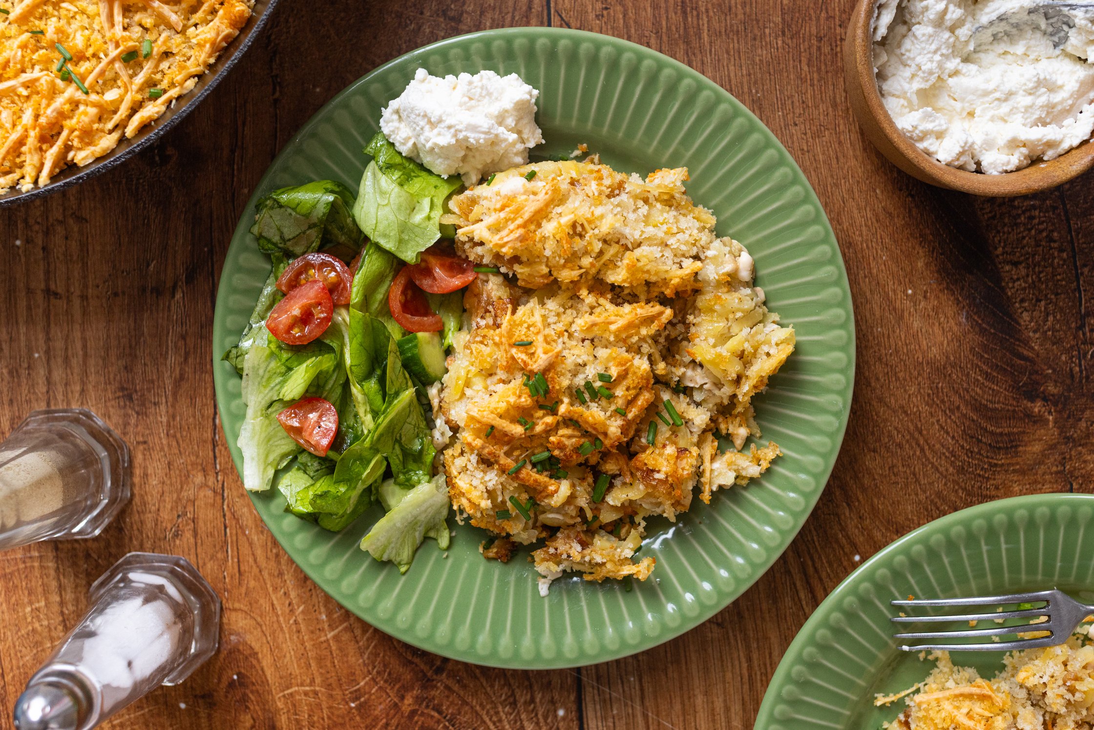 Kartoffelpuffer-Auflauf mit Creme Fraiche auf einem Teller