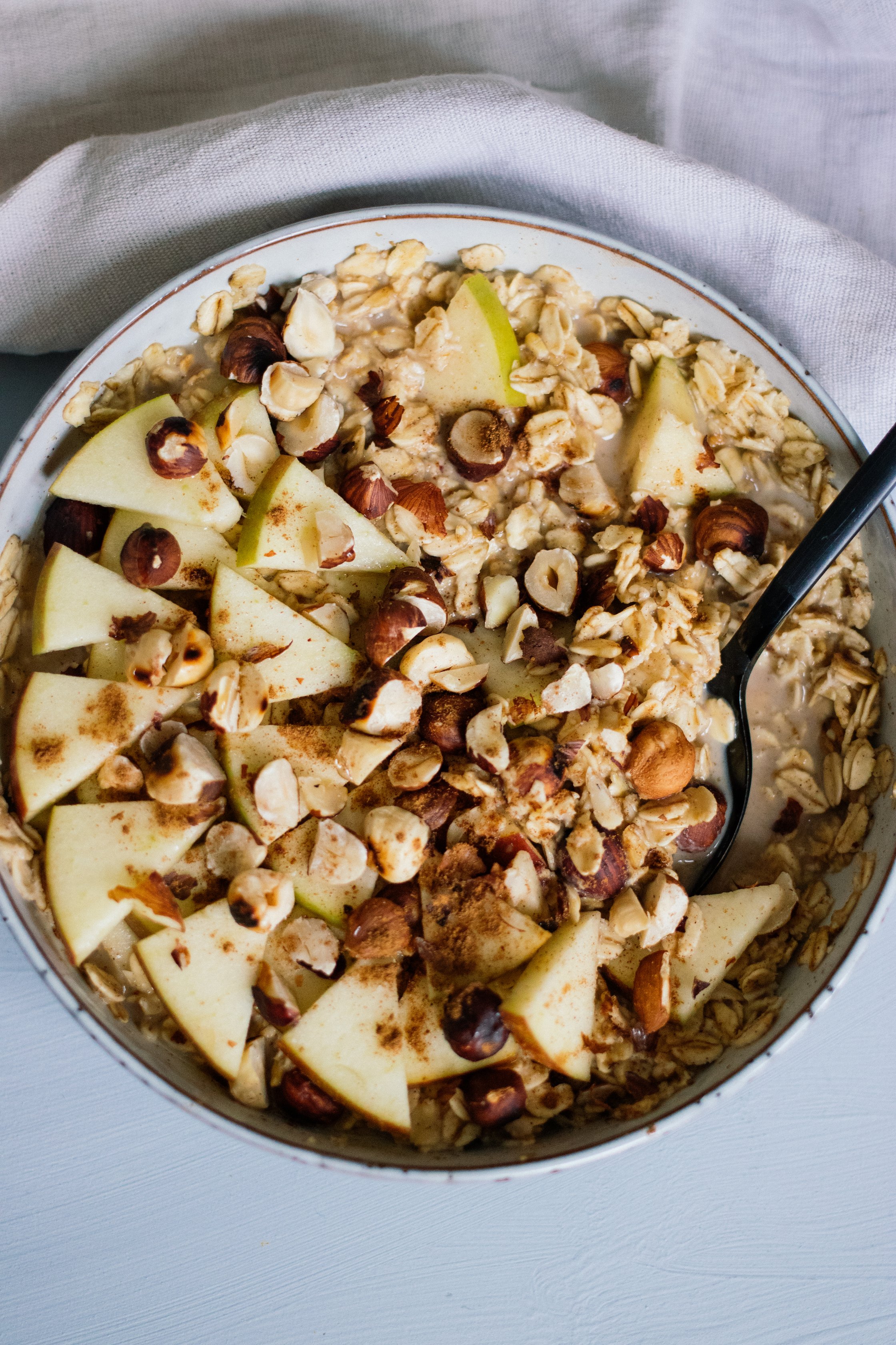 veganes oatmeal mit apfel und haselnüssen ist angerichtet
