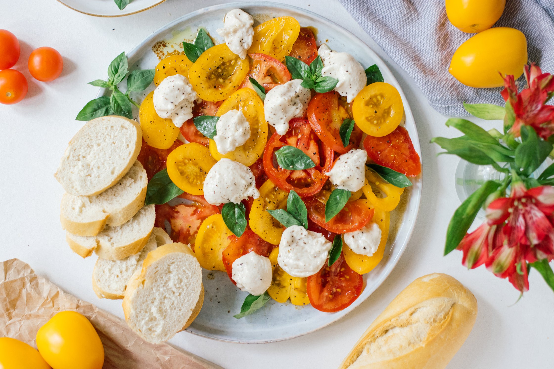 a plate of vegan caprese salad with vegan mozzarella cheese