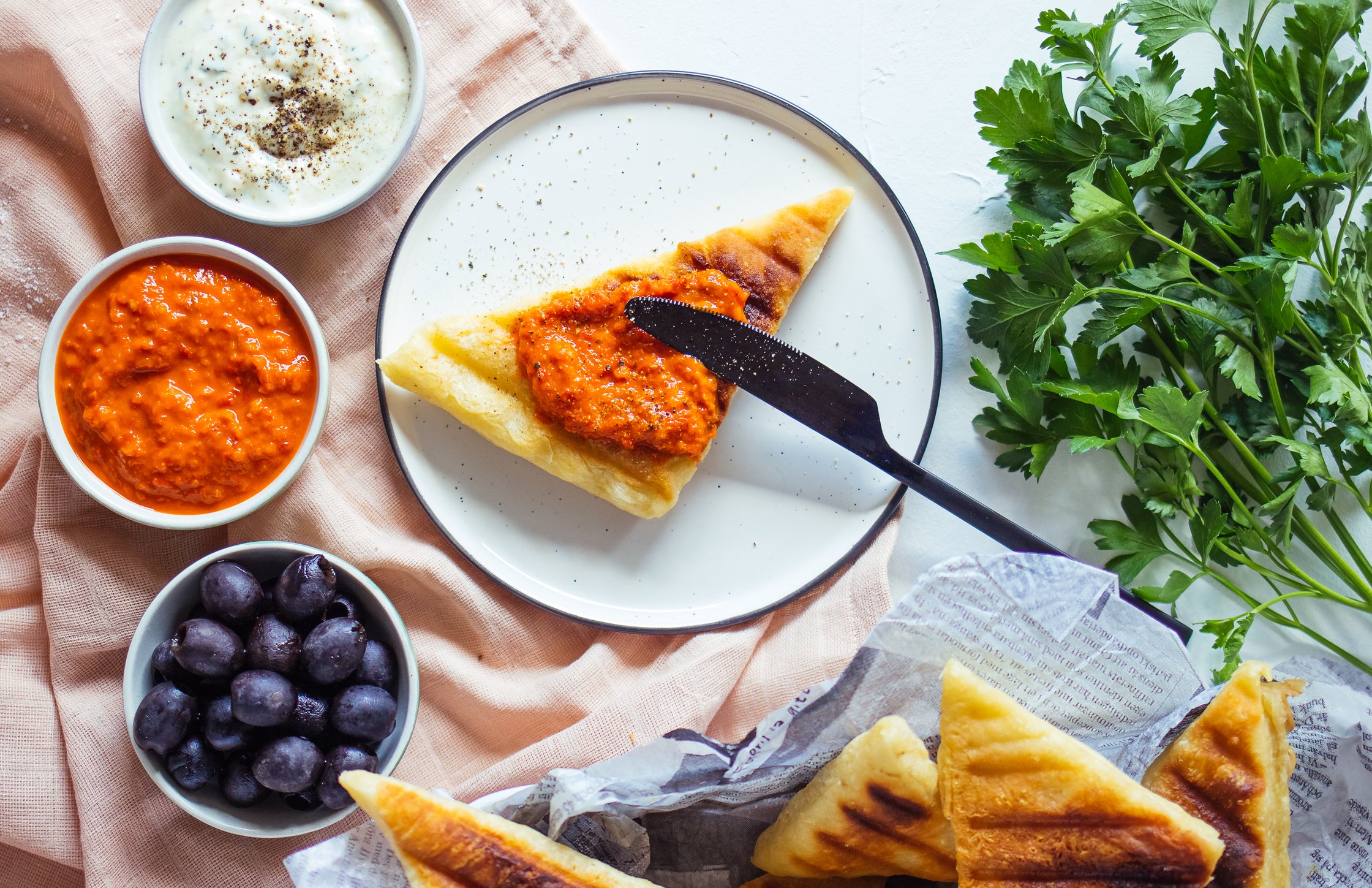Gegrilltes Brot mit Petersilie, Ajvar und Oliven
