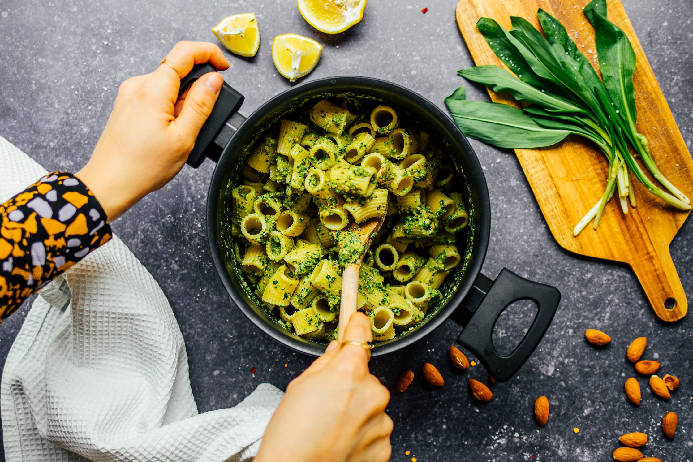Person vermischt Nudeln und veganes Bärlauchpesto