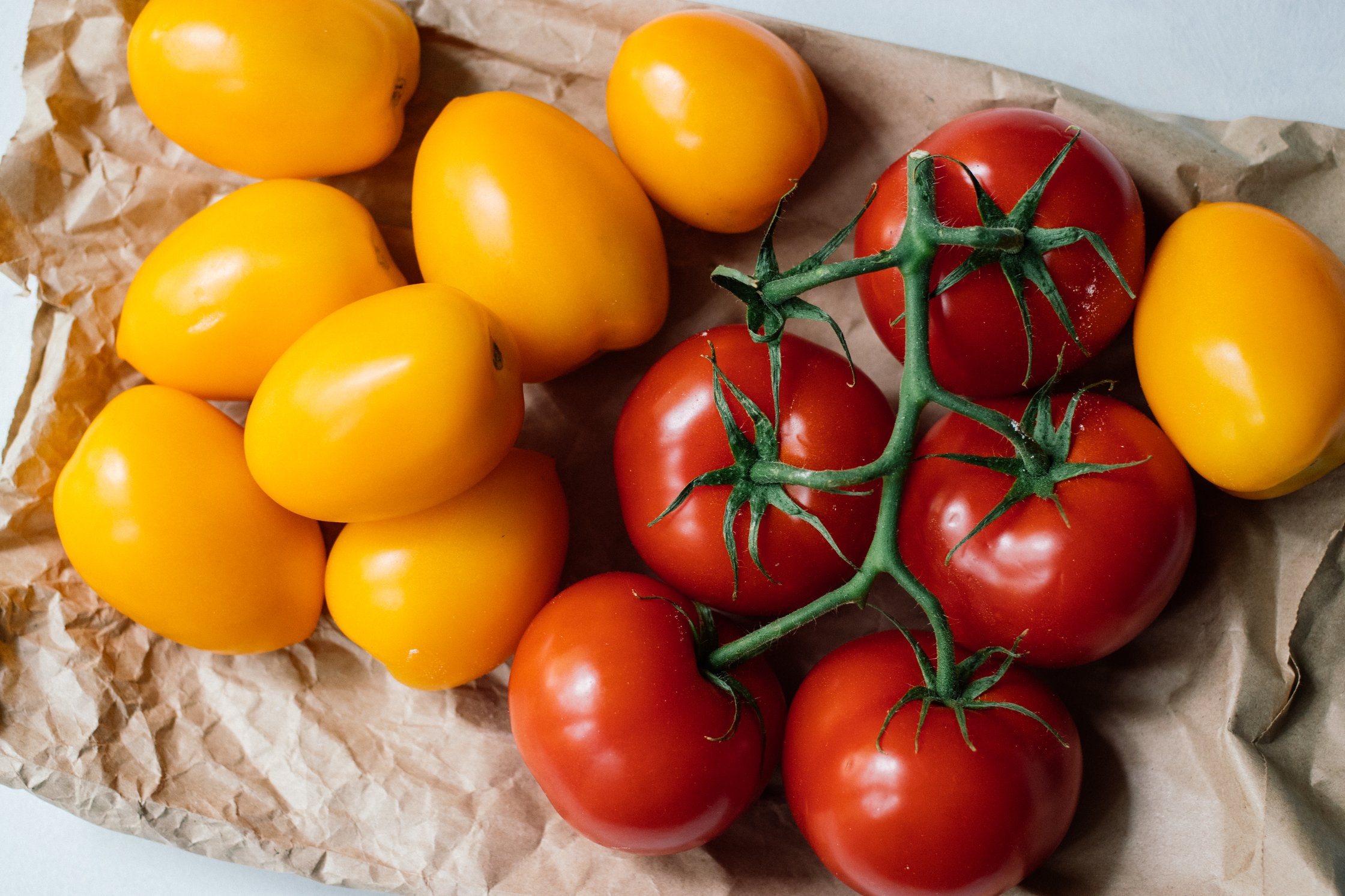 rote und gelbe tomaten auf einer papiertüte