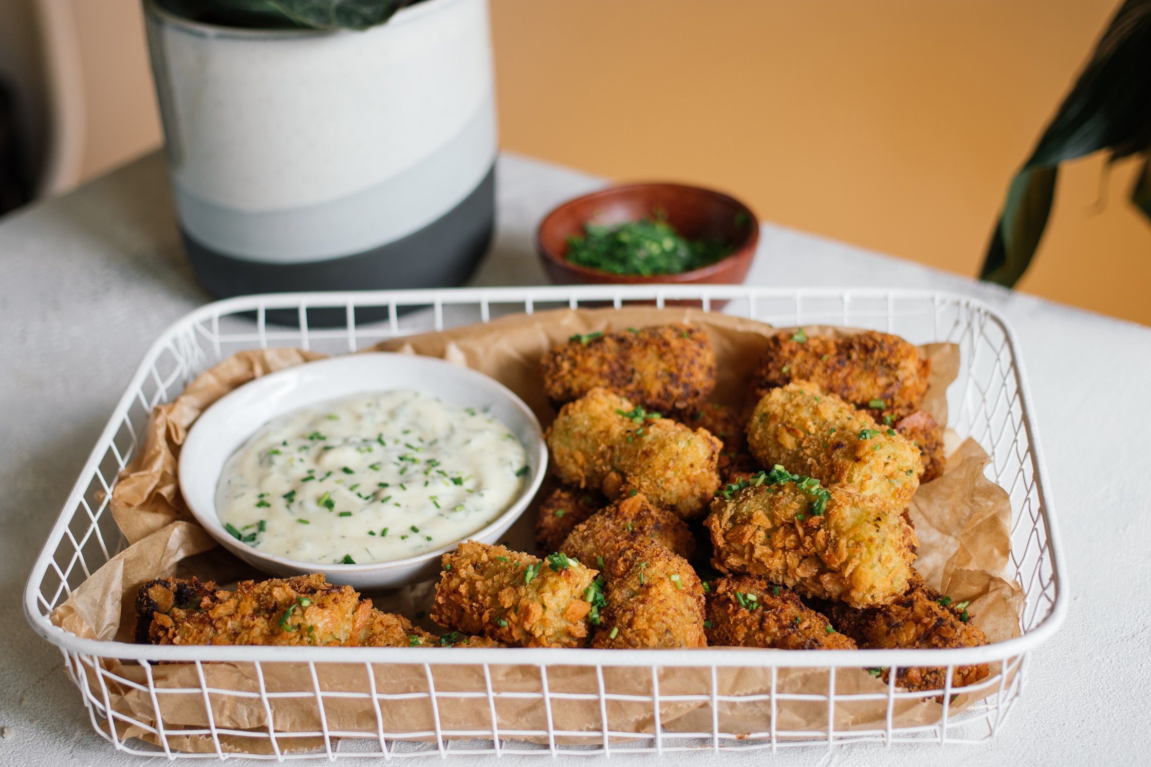 Vegane Brokkoli-Kroketten mit Kräuterdip auf dem tisch