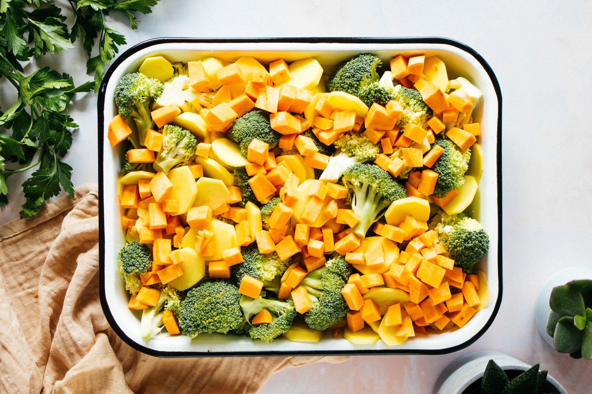 potatoes, broccoli and sweet potato in a casserole form