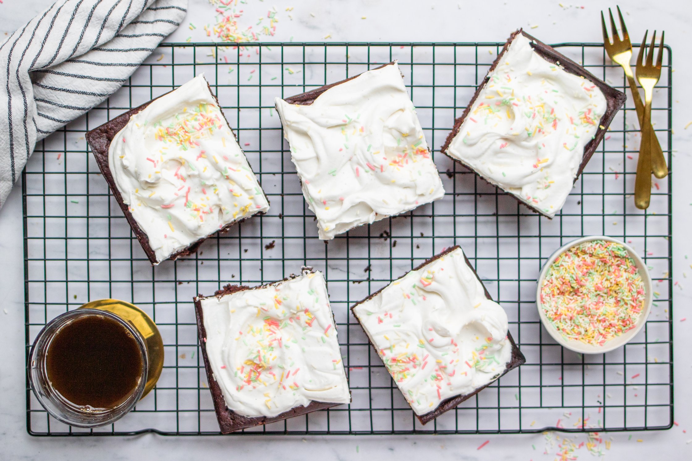 Fünf Stücke Kuchen auf einem Rost mit Kaffee und Gabeln